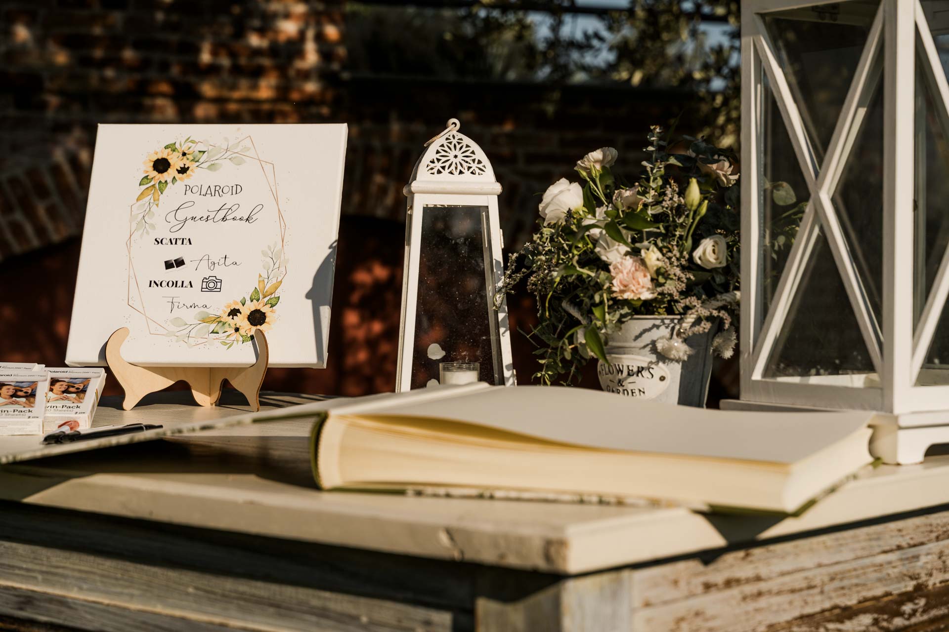 Il guestbook di polaroid, con la lanterna e i fiori