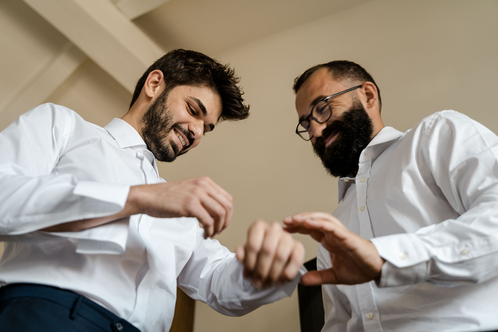 Lo sposo ride mentre l'amico gli allaccia i polsini
