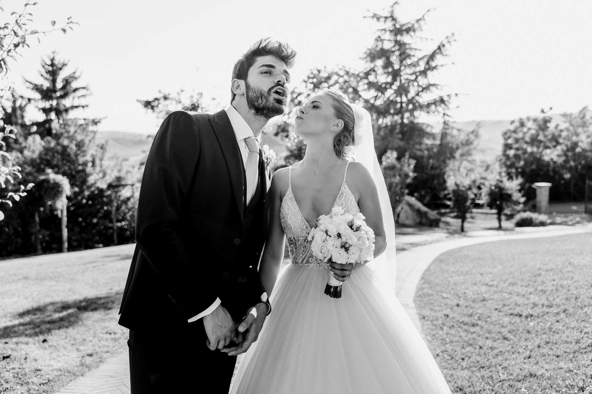 In bianco e nero, lo sposo fa una smorfia e la sposa ride