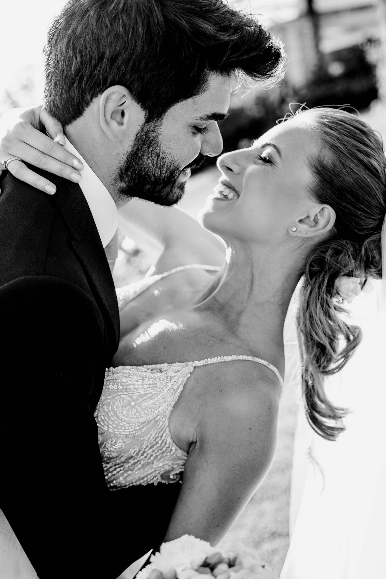In bianco e nero, la sposa ride tra le braccia dello sposo