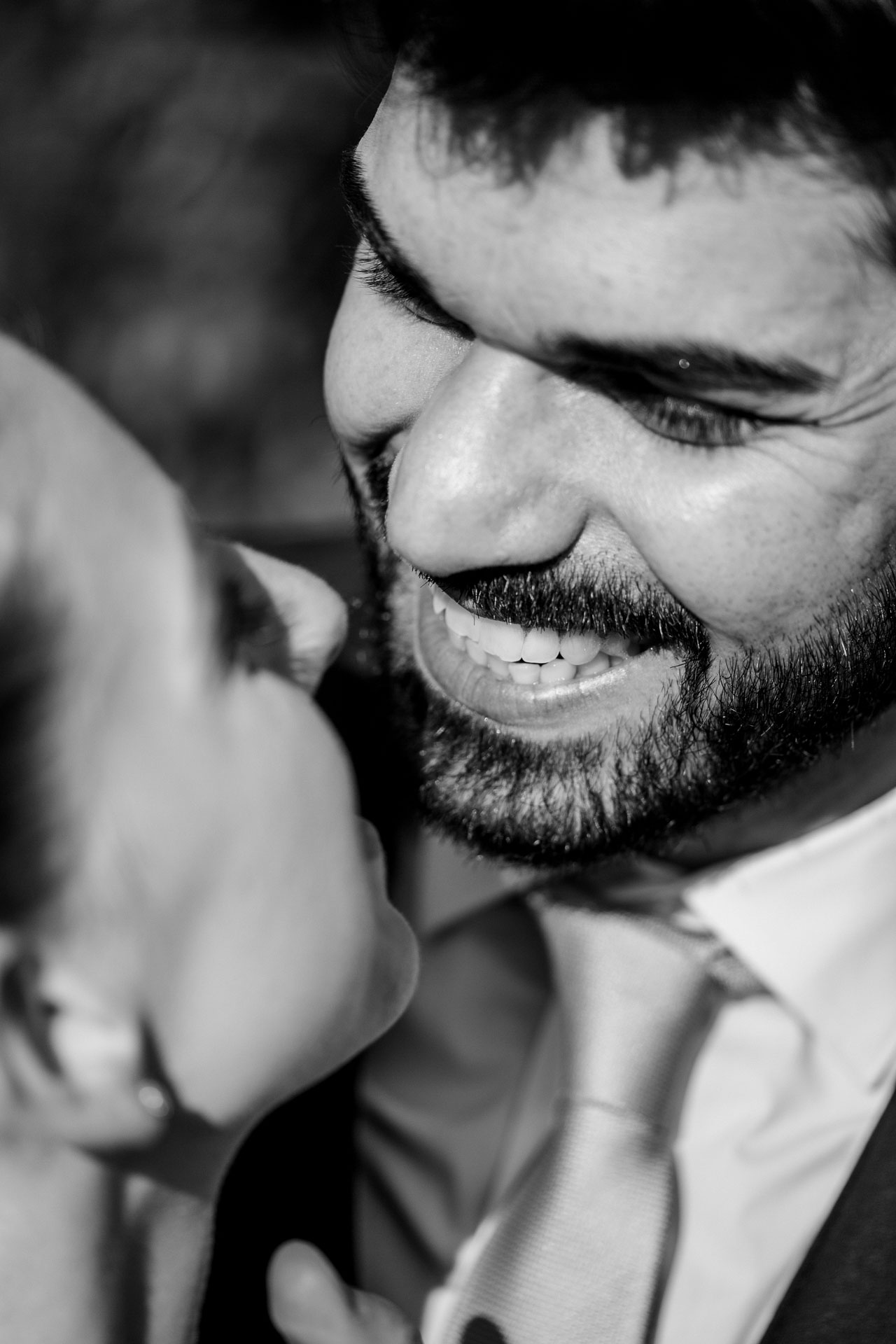 In bianco e nero, il sorriso dello sposo vicinissimo alla sposa
