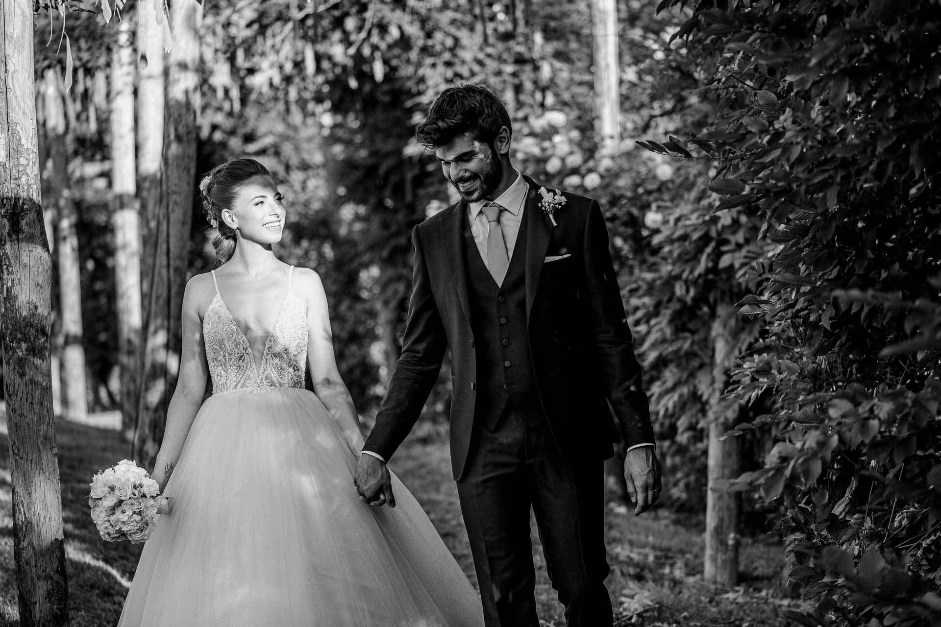 In bianco e nero, gli sposi passeggiano mano nella mano tra gli alberi
