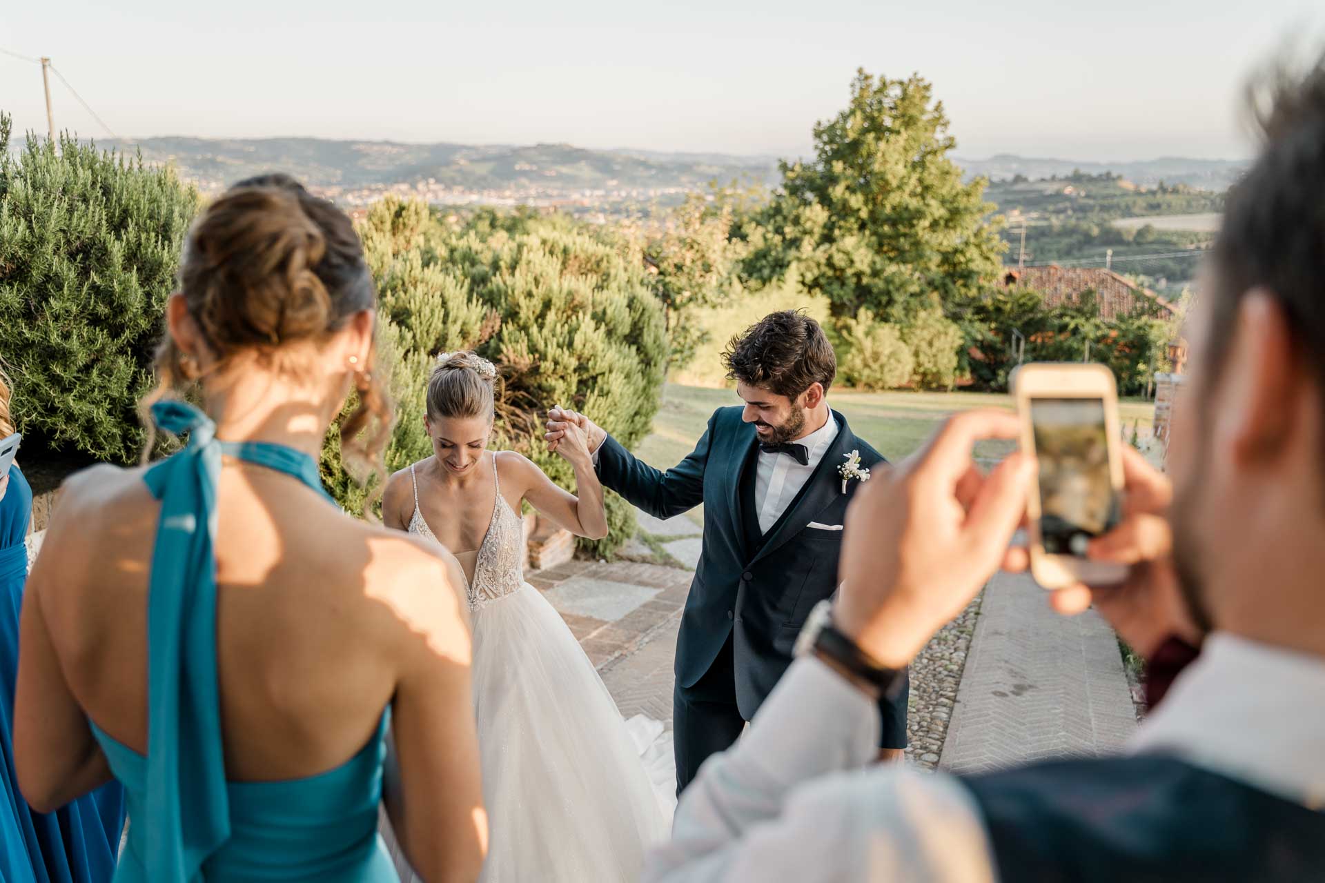 Gli sposi entrano alla festa e un invitato li riprende con il telefono