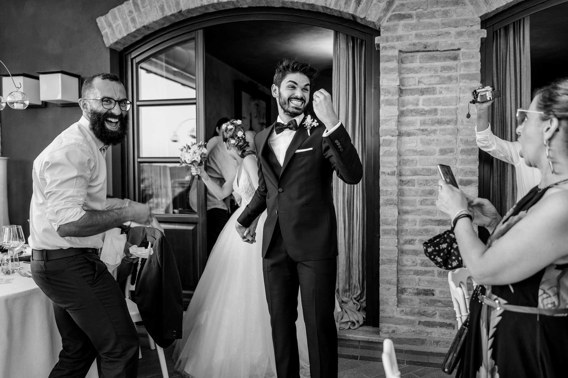 In bianco e nero, l'ingresso degli sposi tra il ballo dell'amico e gli applausi