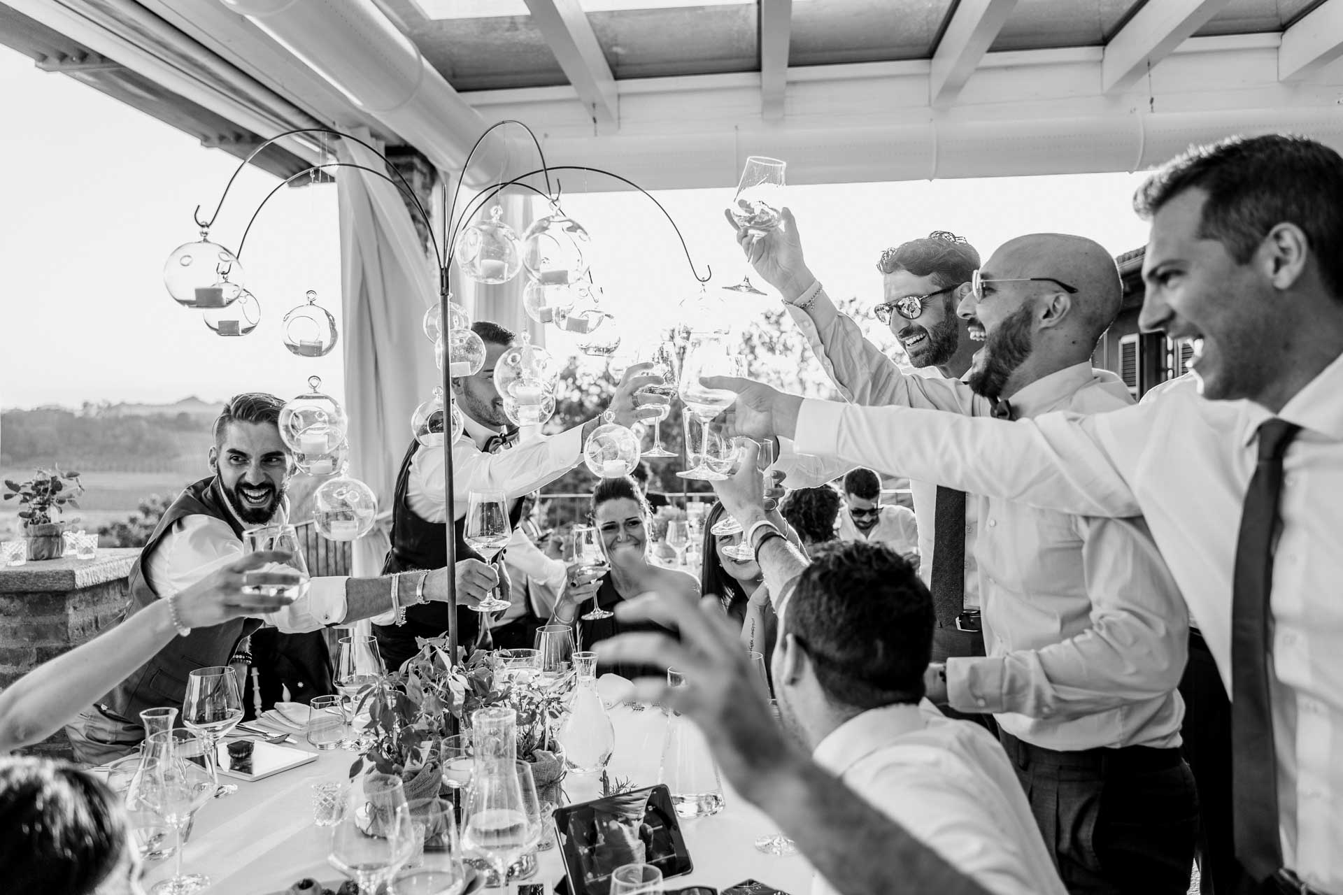 In bianco e nero, gli amici brindano in piedi sotto la veranda