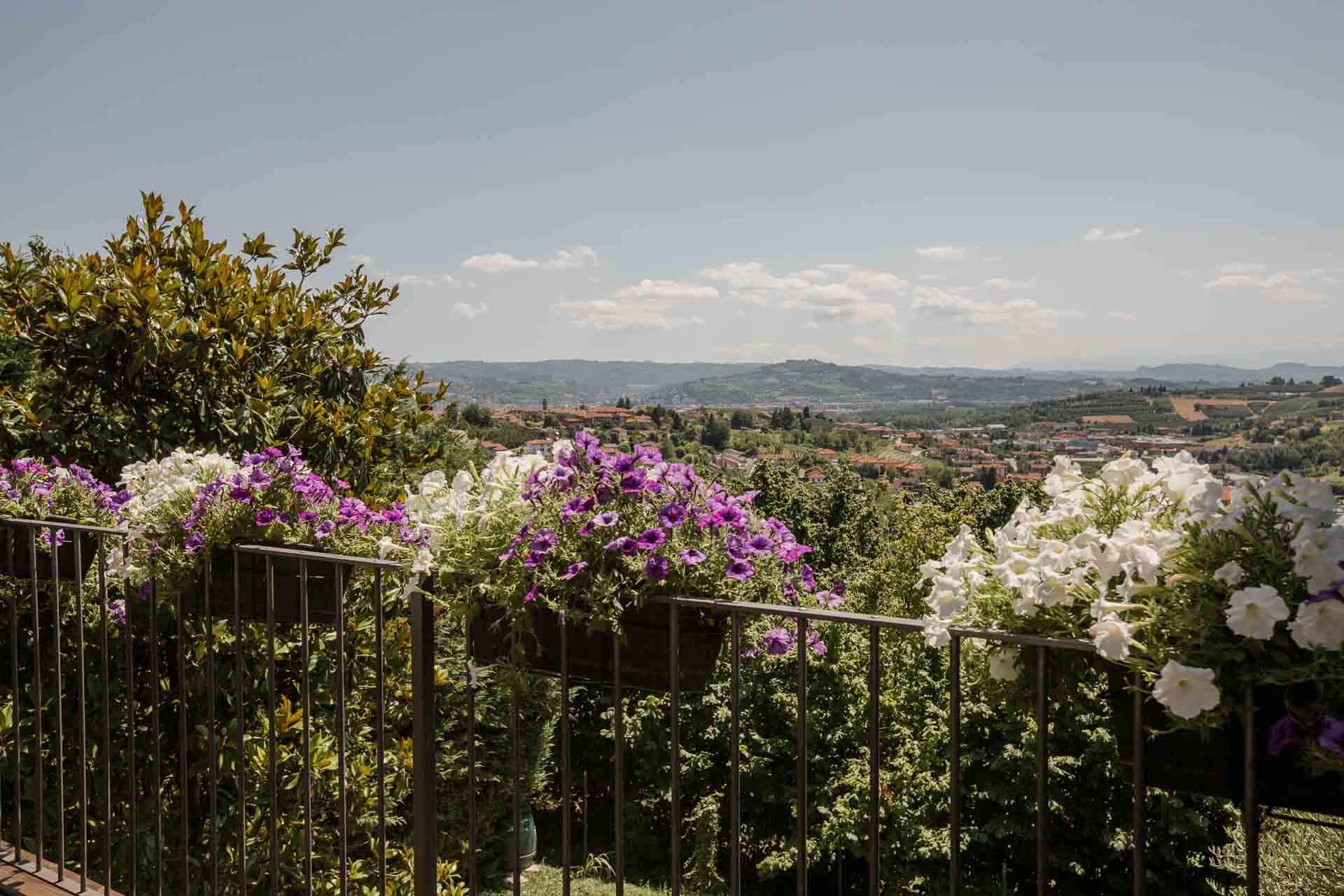 La ringhiera fiorita di petunie viola e bianche, con le colline sullo sfondo