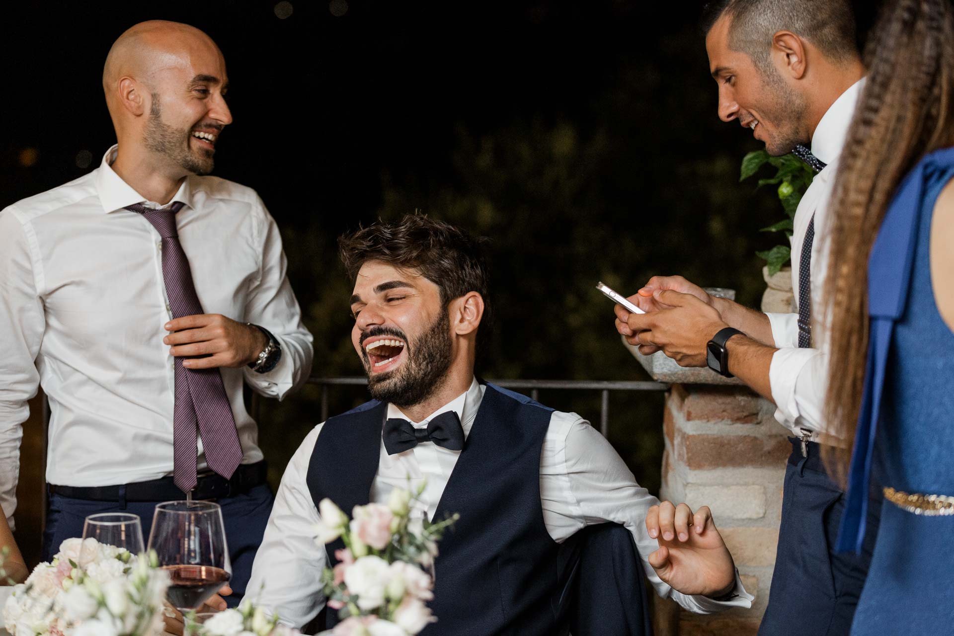 Lo sposo ride al tavolo con gli amici