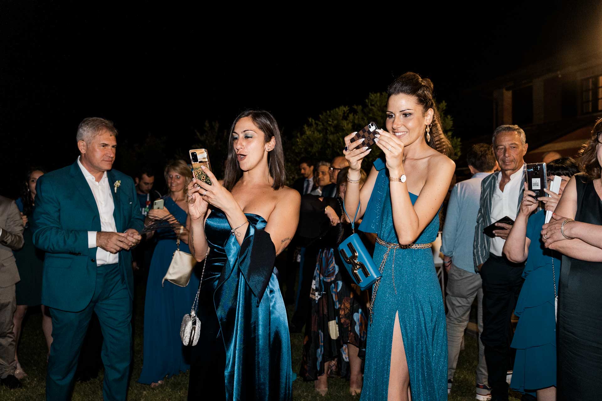 Gli invitati fotografano gli sposi con il telefono