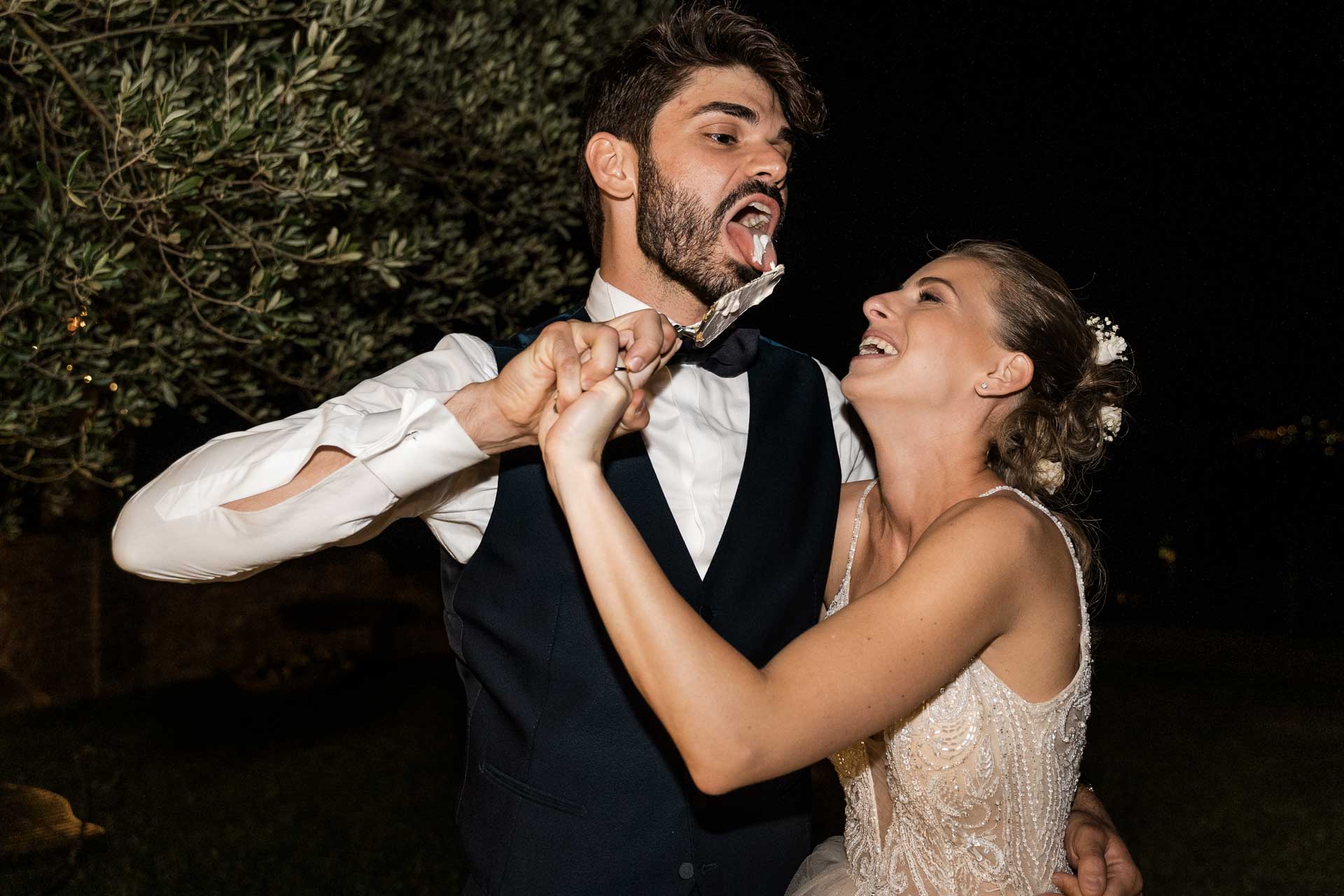 Gli sposi si imboccano la torta, ridendo