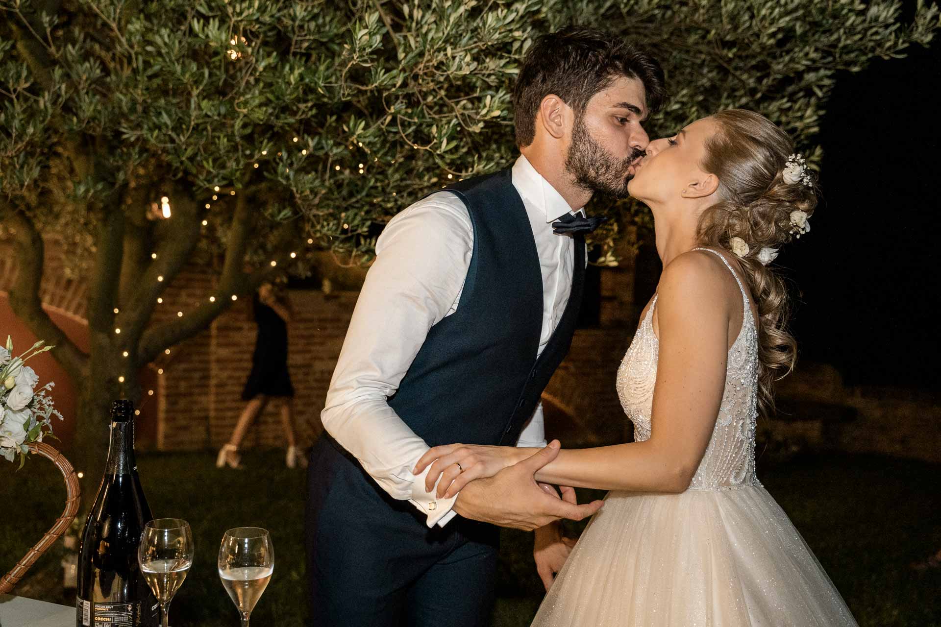 Il bacio degli sposi sotto l'ulivo illuminato