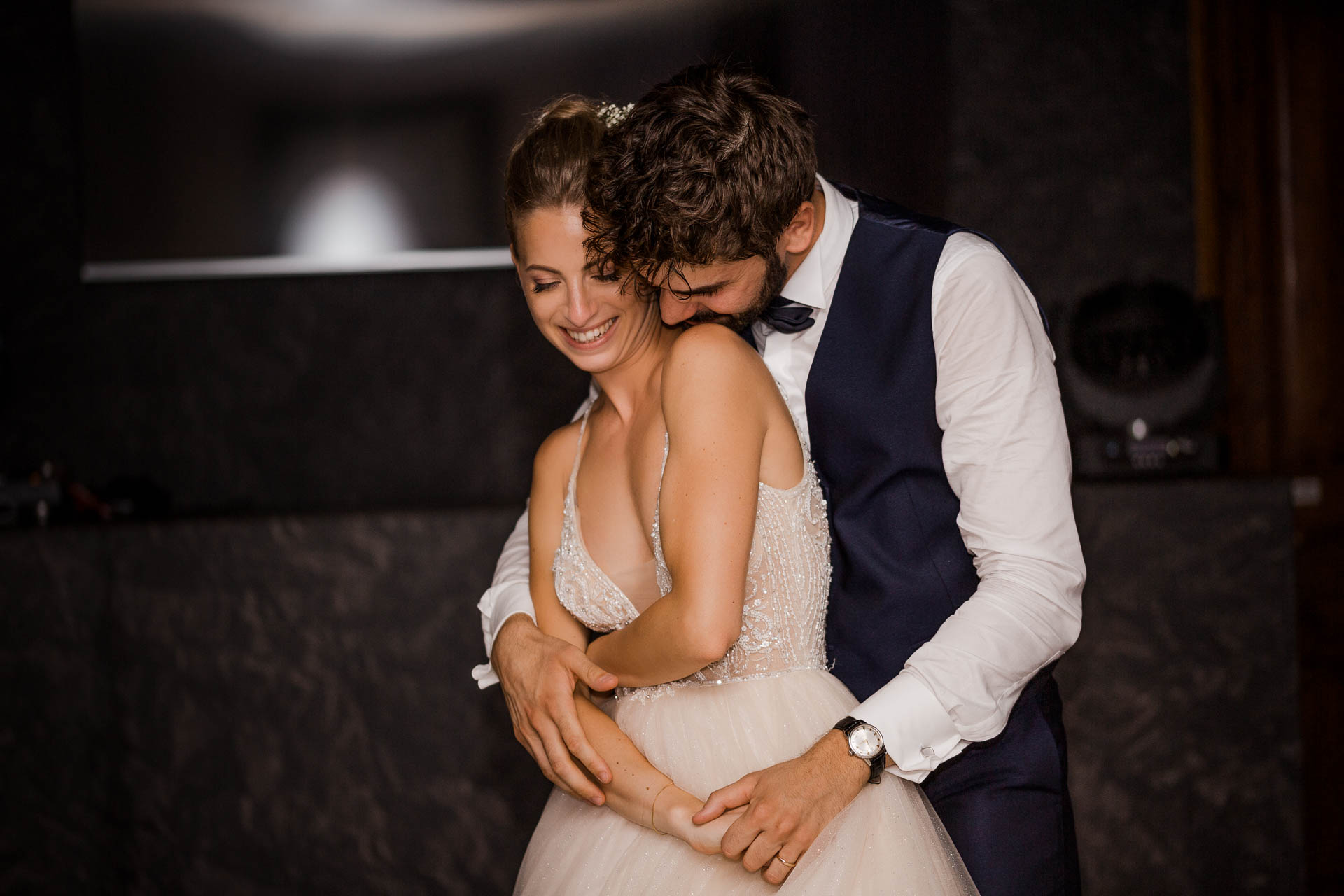 Lo sposo abbraccia la sposa da dietro, e lei sorride