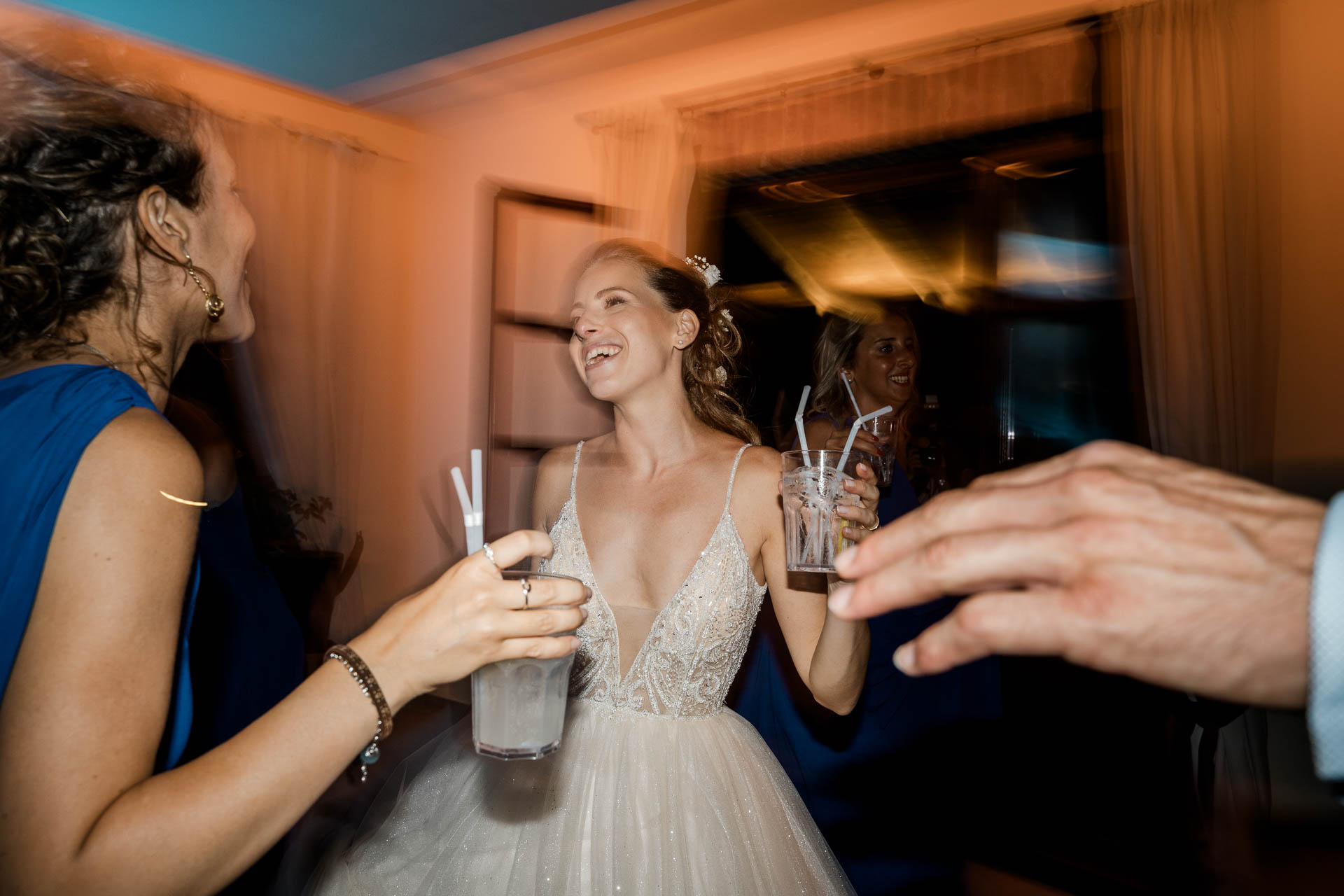 La sposa ride con il bicchiere in mano, tra le amiche