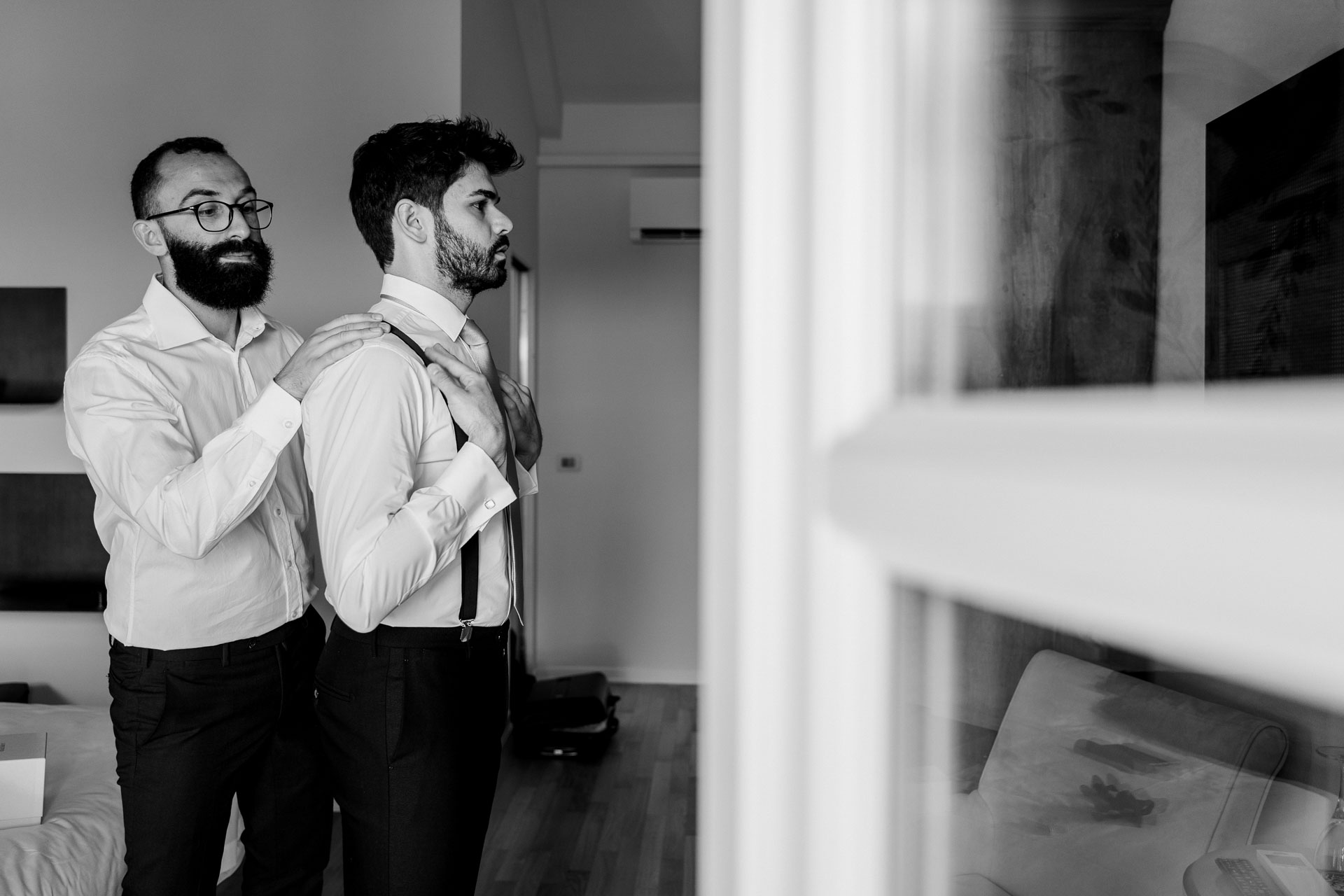 In bianco e nero, lo sposo e l'amico si vestono fianco a fianco