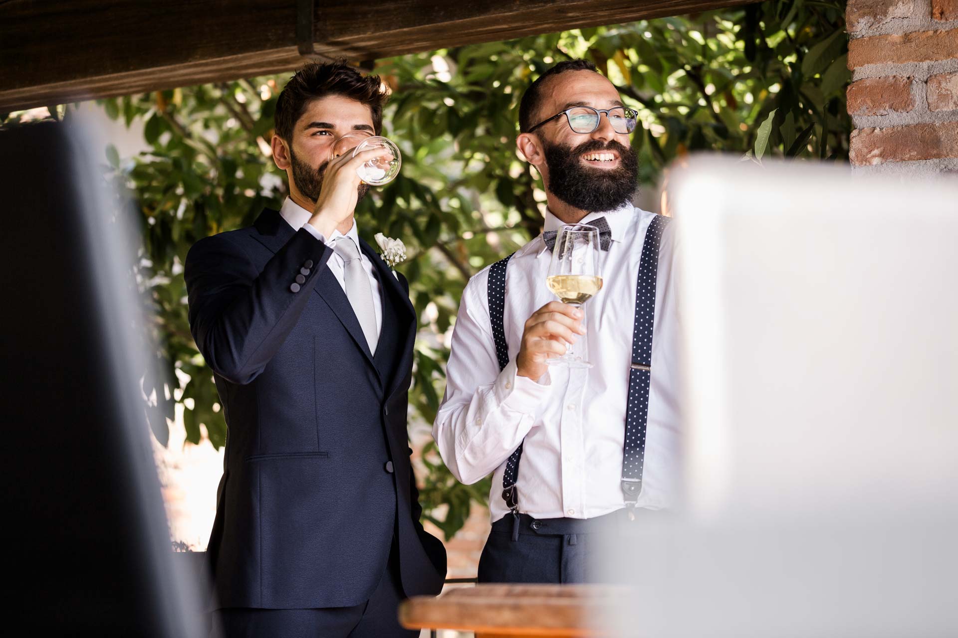 Lo sposo e l'amico in papillon bevono sulla terrazza