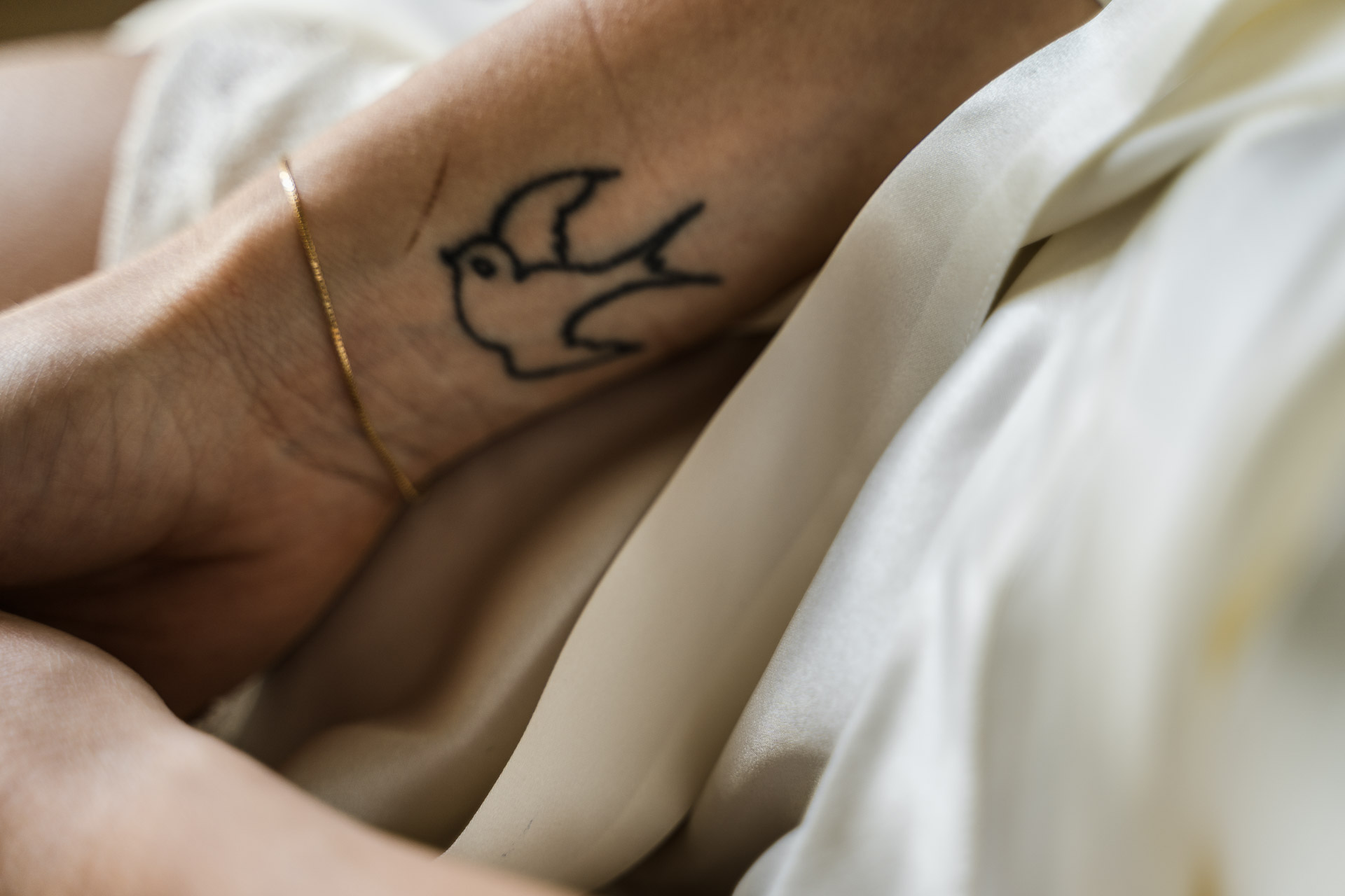 Il tatuaggio di una rondine sul polso della sposa