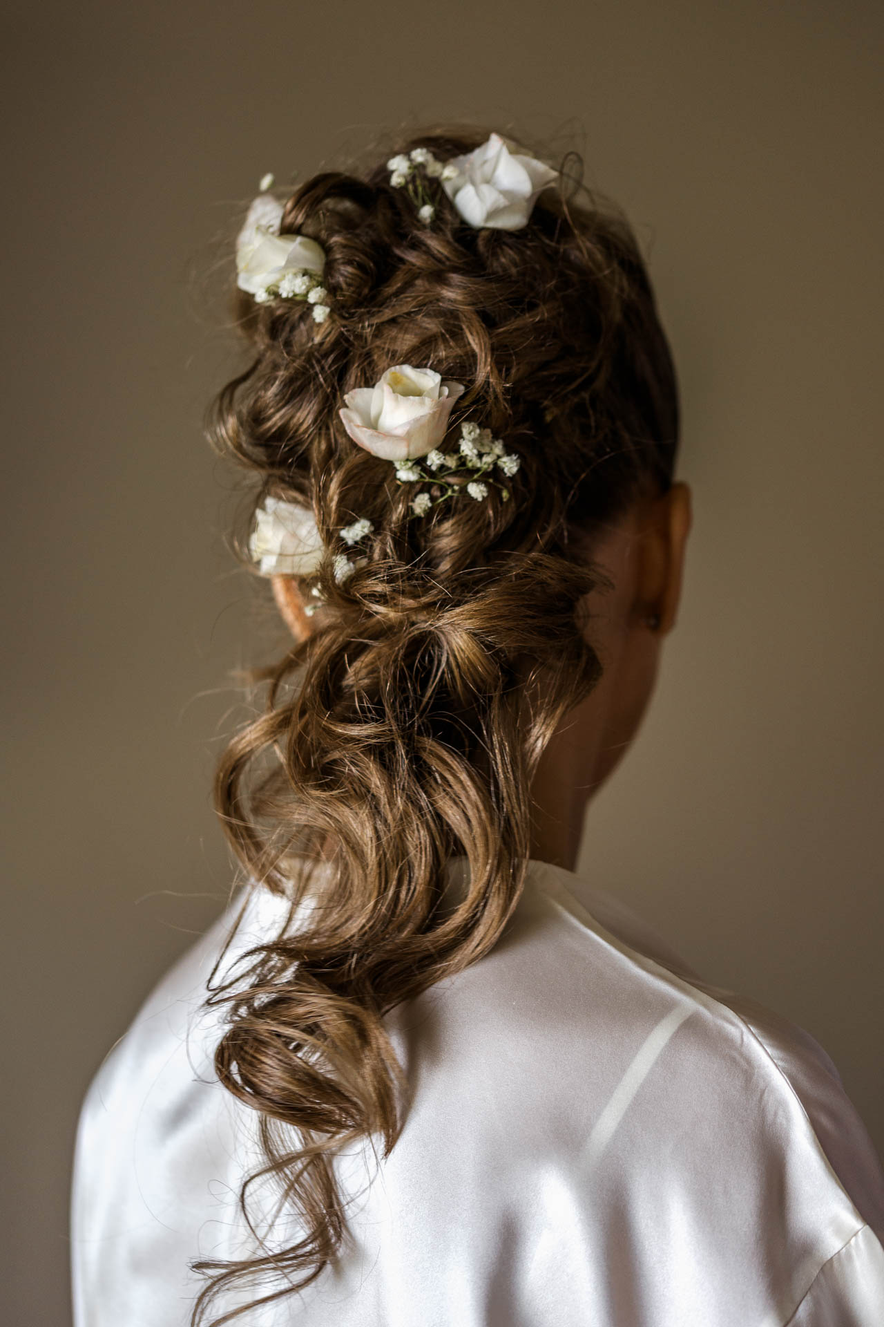 L'acconciatura della sposa, con le rose bianche tra i boccoli