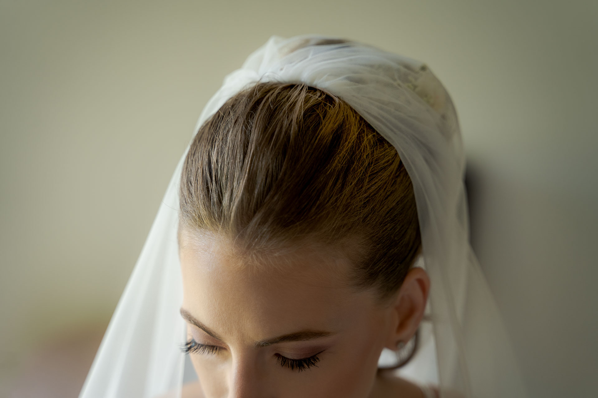 Lo sguardo basso della sposa sotto il velo