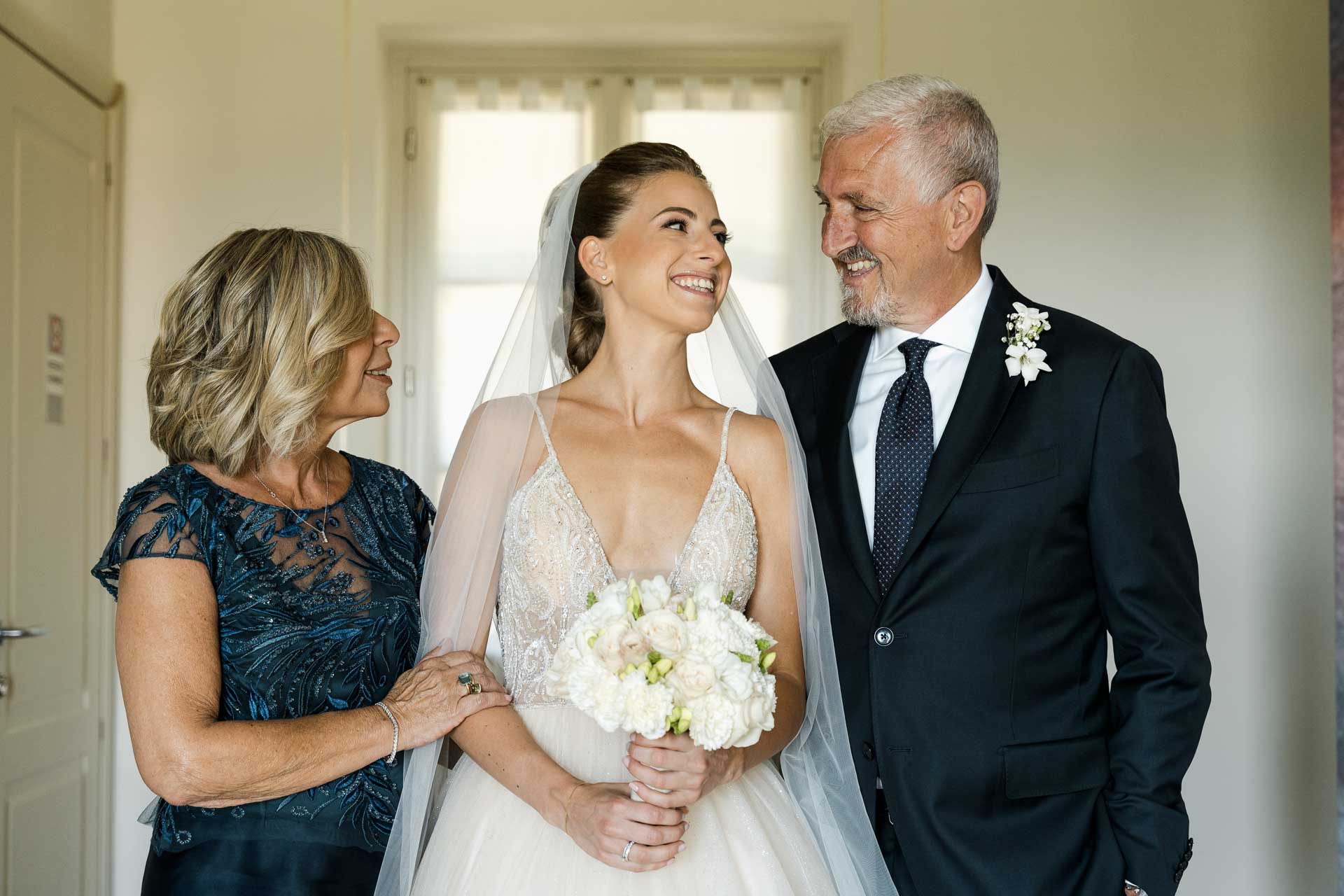 La sposa con il bouquet tra la mamma e il papà