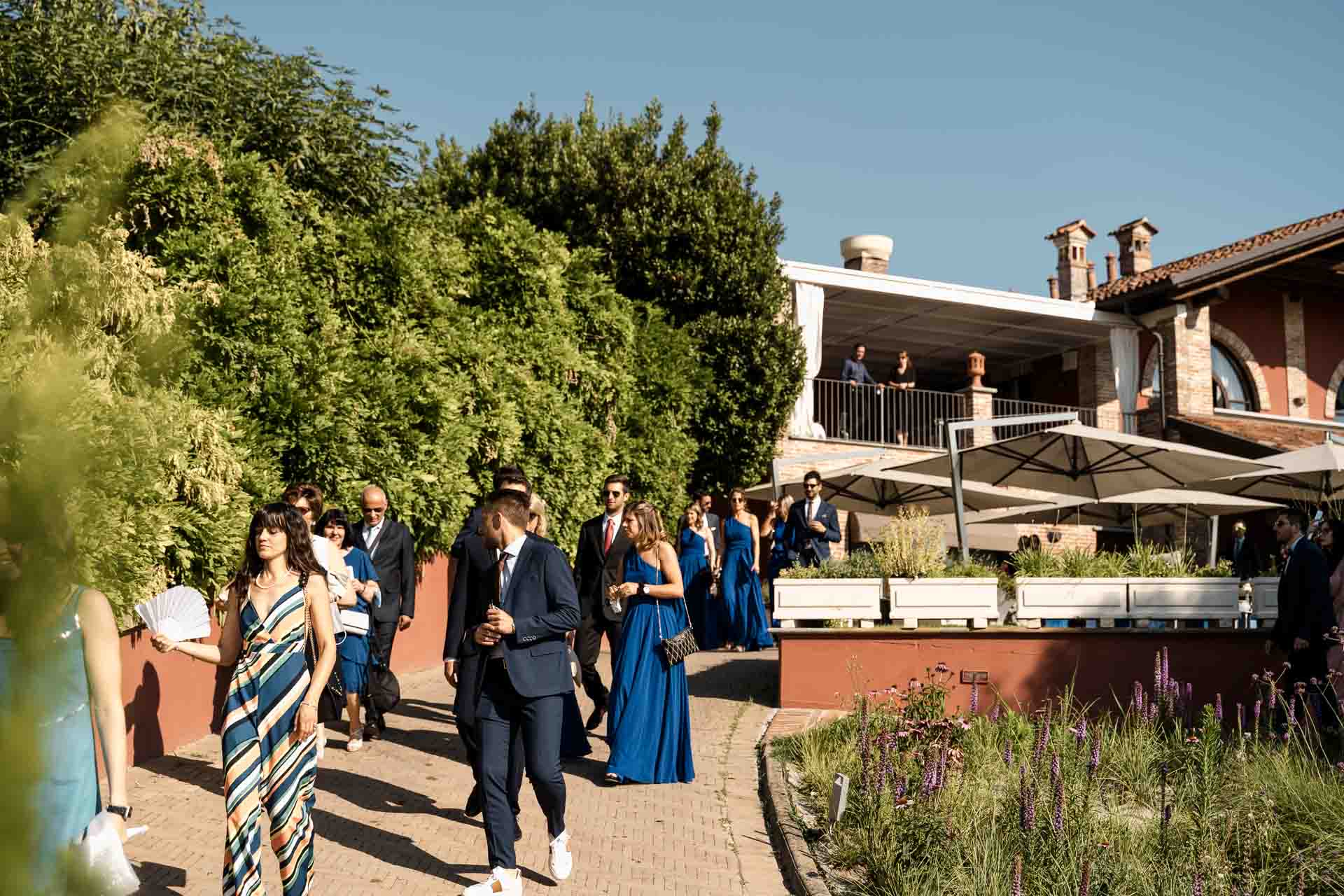 Gli invitati arrivano lungo il viale di mattoni