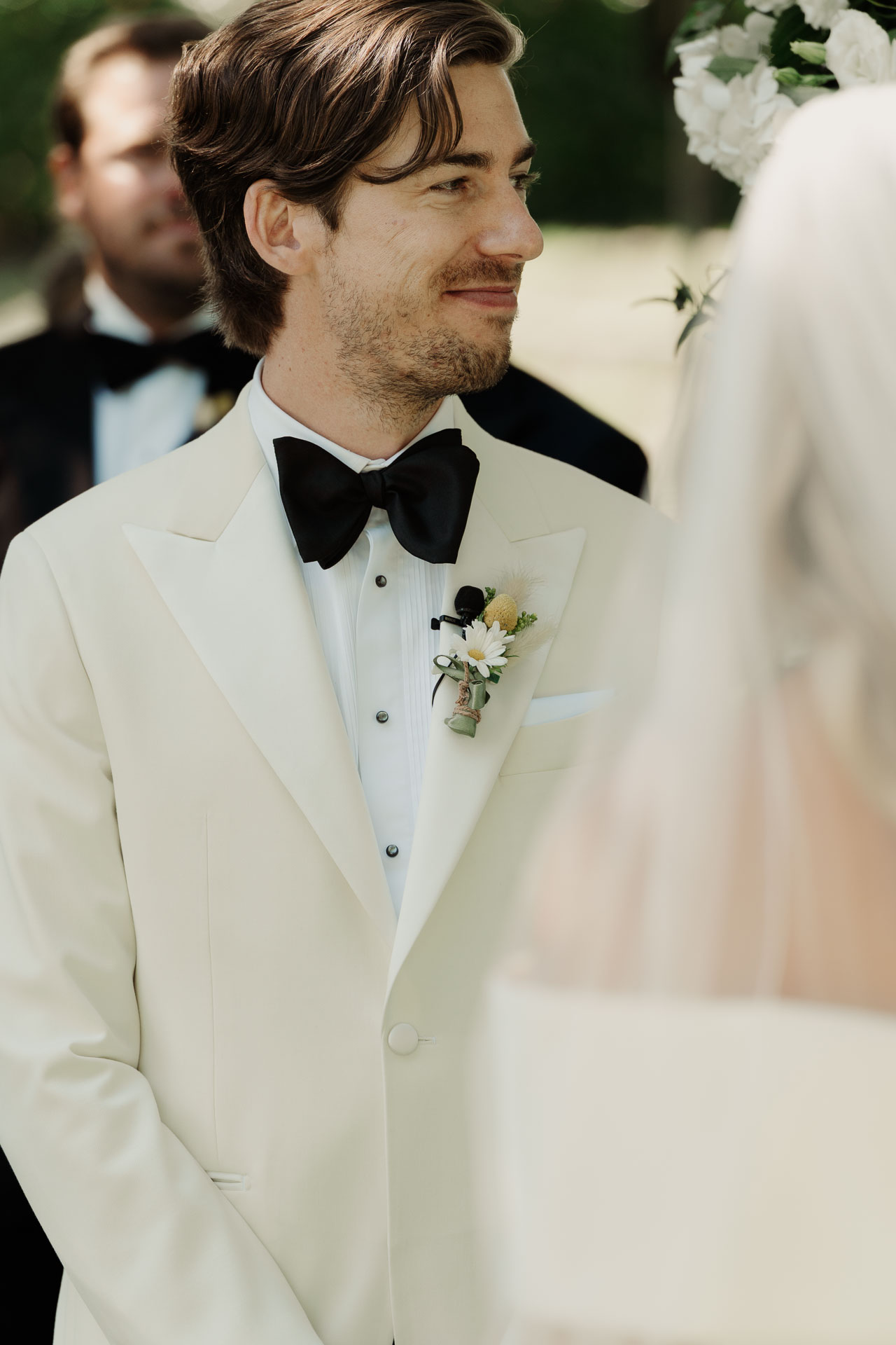 Lo sposo sorride alla sposa durante la cerimonia