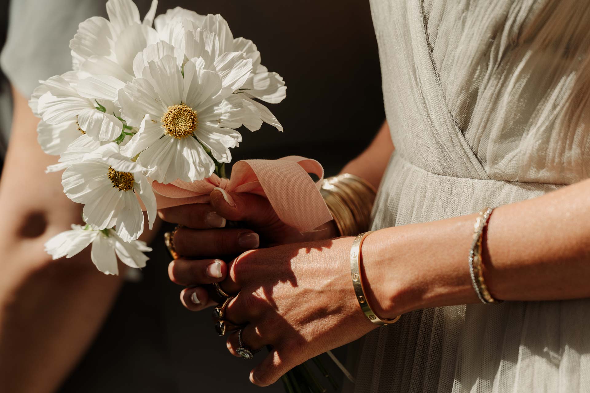 Le mani delle damigelle con il bouquet di margherite