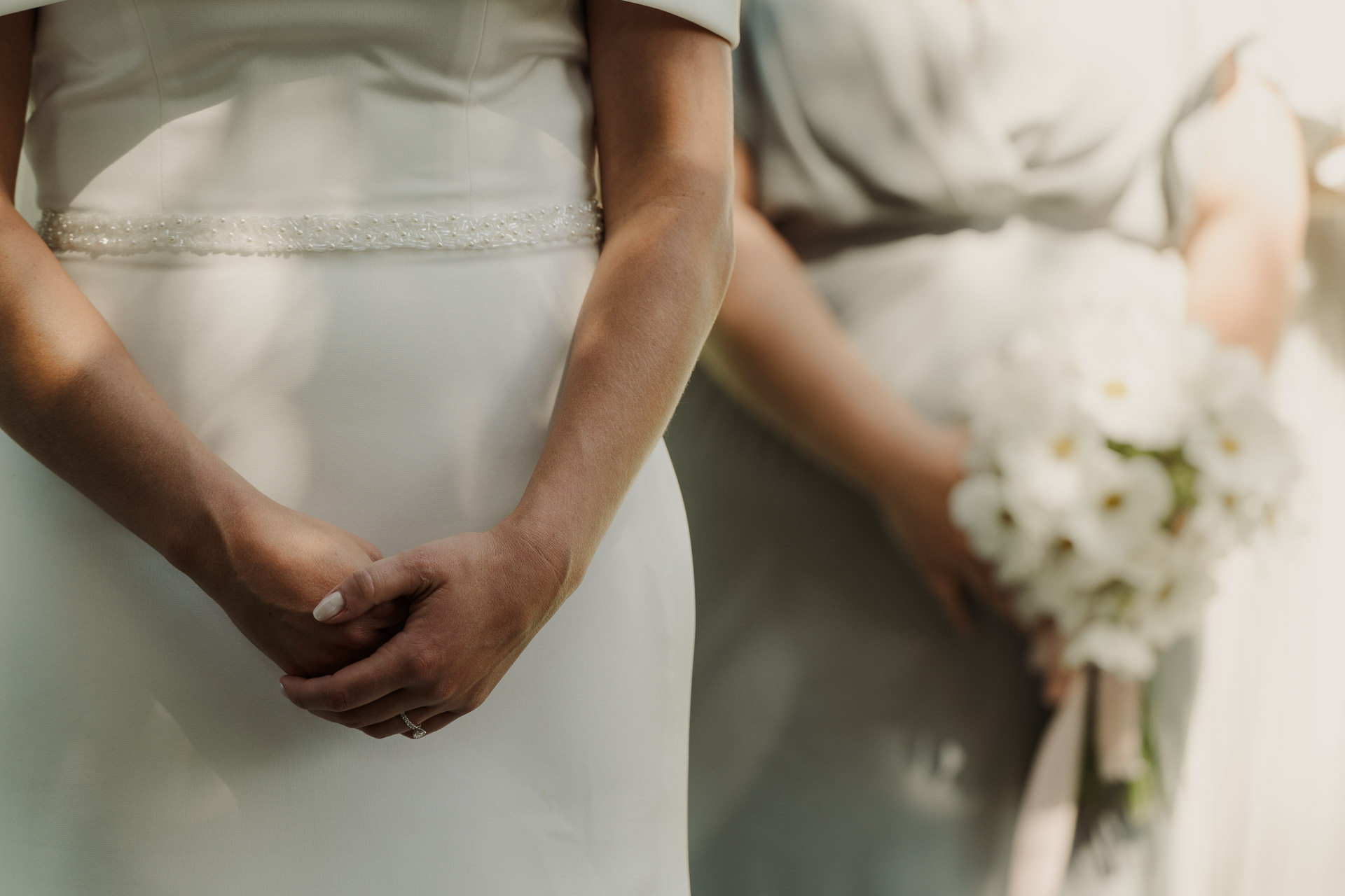Le mani della sposa e il bouquet della damigella