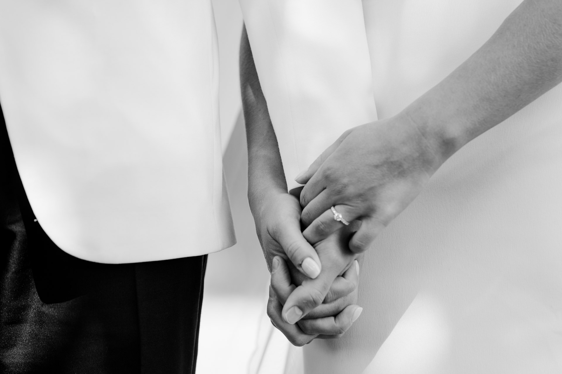 In bianco e nero, le mani degli sposi intrecciate
