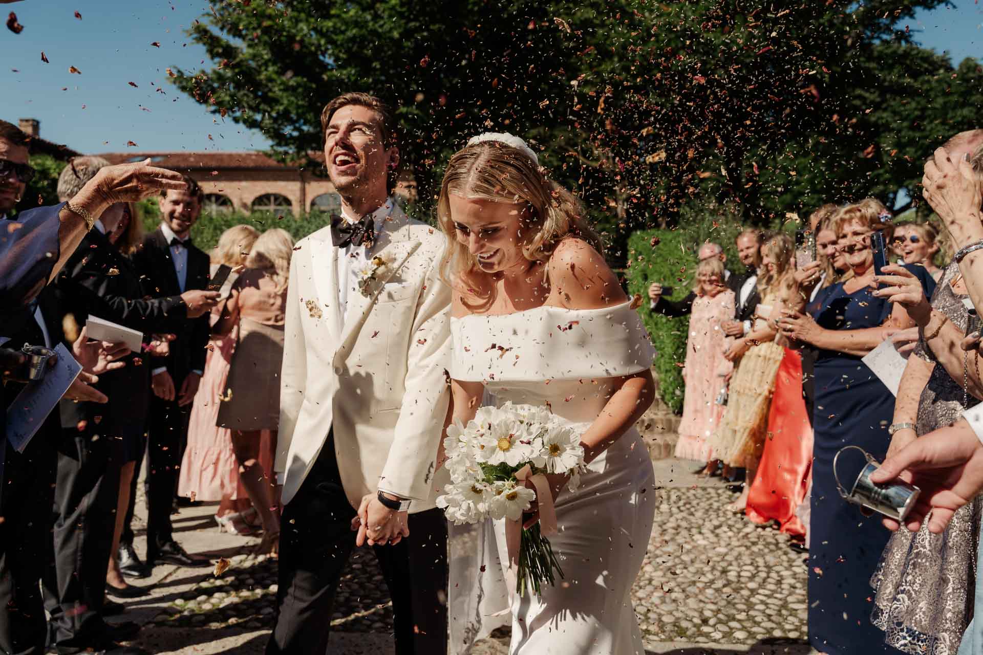 Gli sposi escono tra i petali lanciati dagli invitati