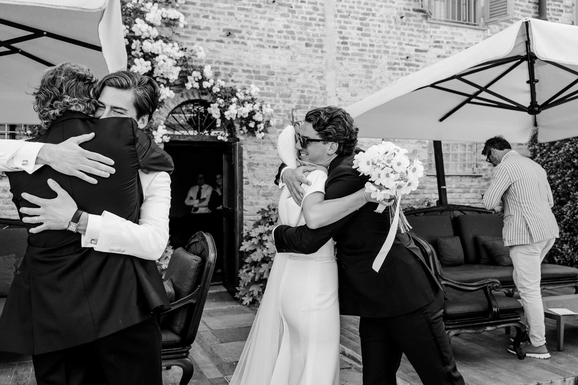 In bianco e nero, gli abbracci agli sposi nella corte