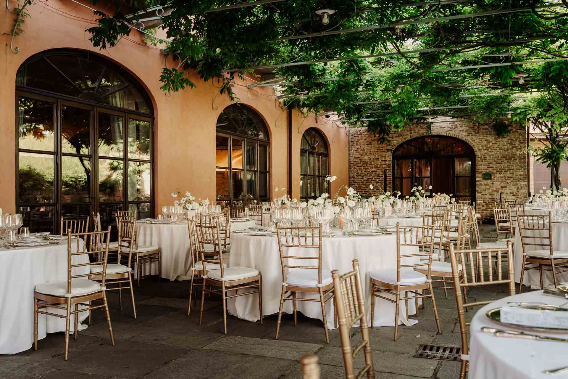 La cena apparecchiata sotto il pergolato del Relais Sant'Uffizio, davanti alle finestre ad arco