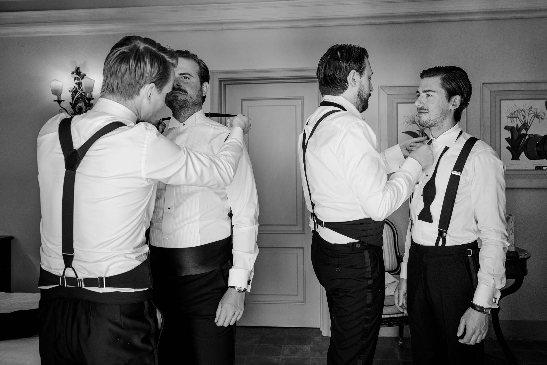 In bianco e nero, gli amici dello sposo si aiutano con i papillon