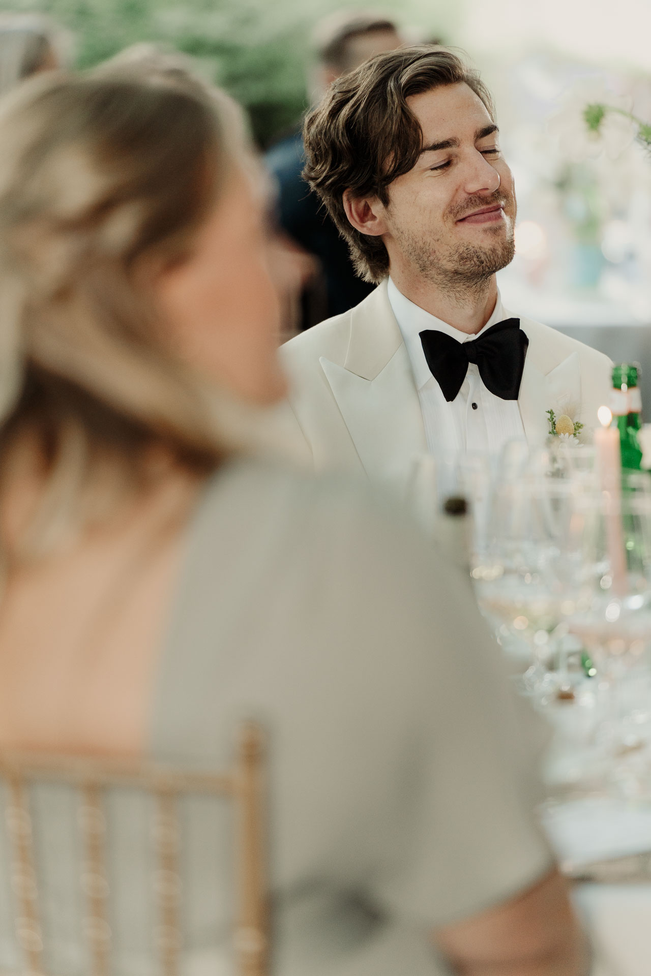Lo sposo sorride a tavola, tra gli invitati