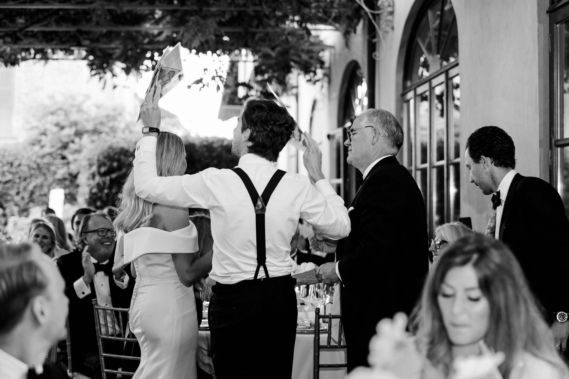 In bianco e nero, lo sposo in bretelle tra gli invitati