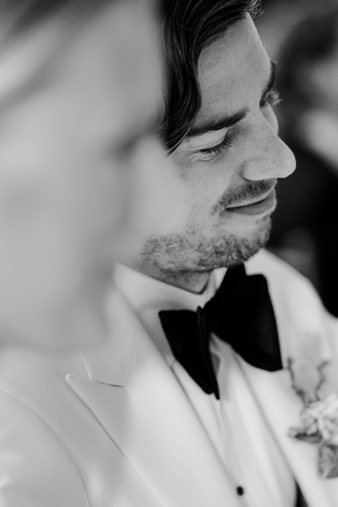 In bianco e nero, lo sposo sorride a occhi bassi