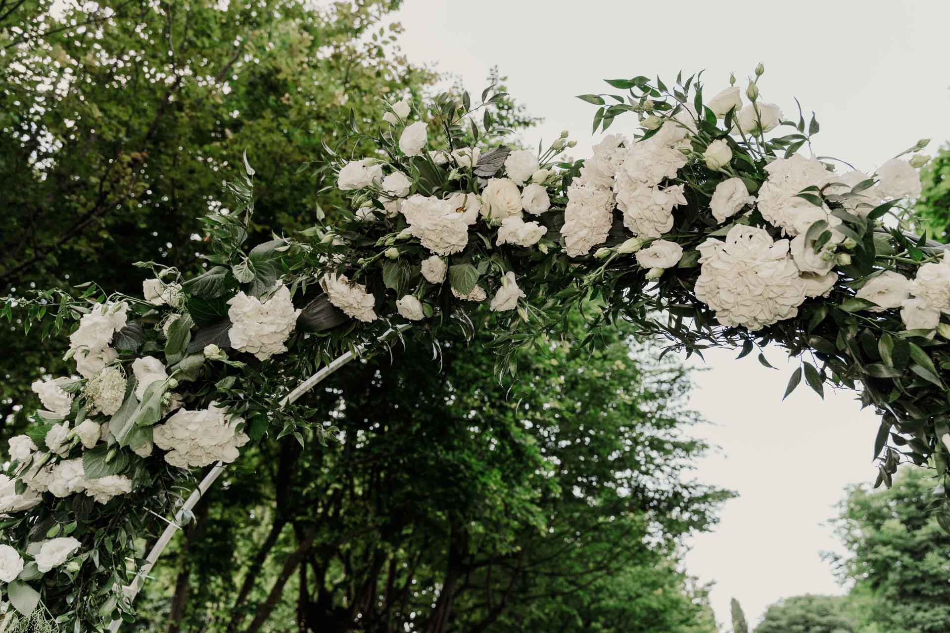 L'arco di fiori bianchi tra il verde