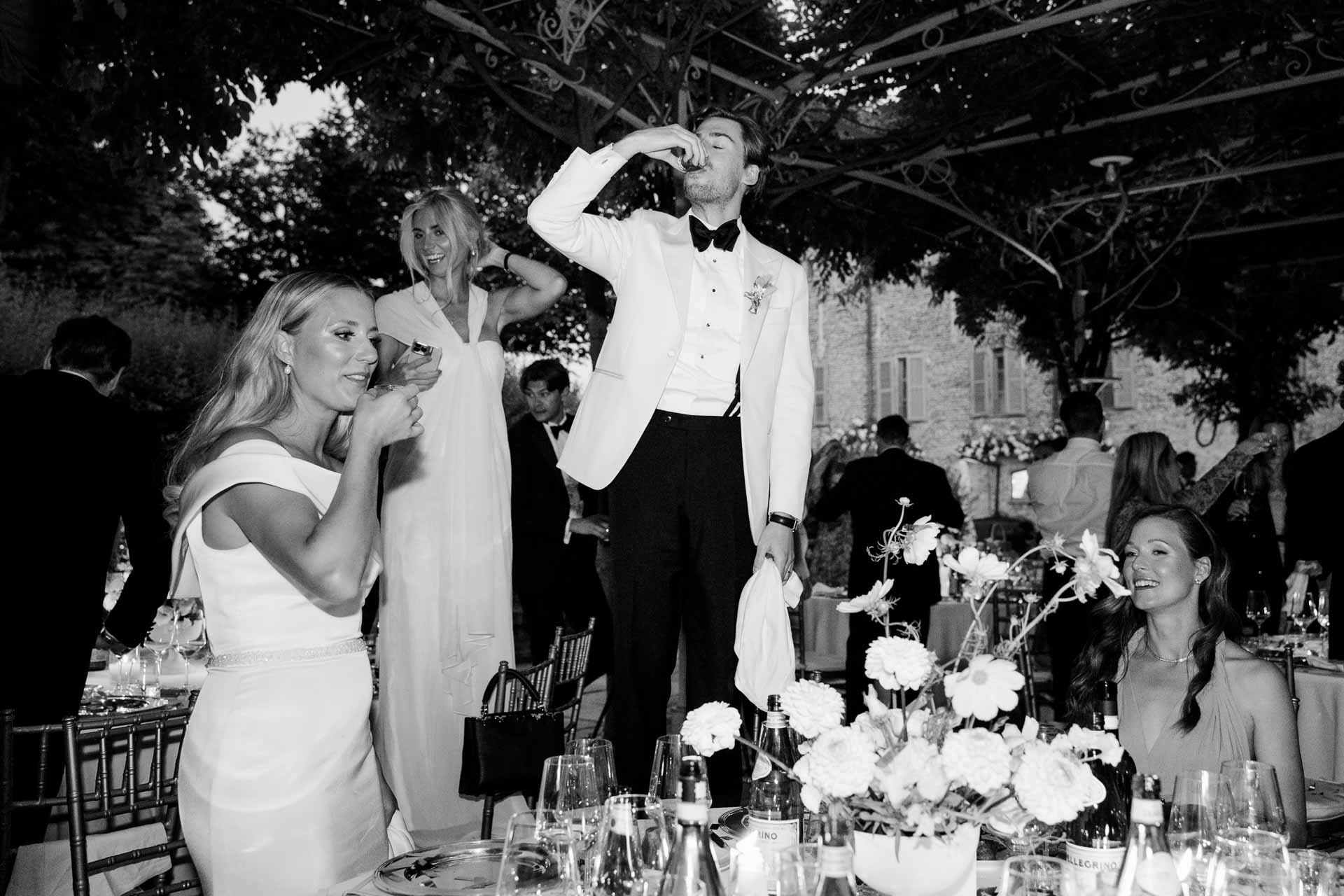 In bianco e nero, gli sposi ridono tra gli invitati
