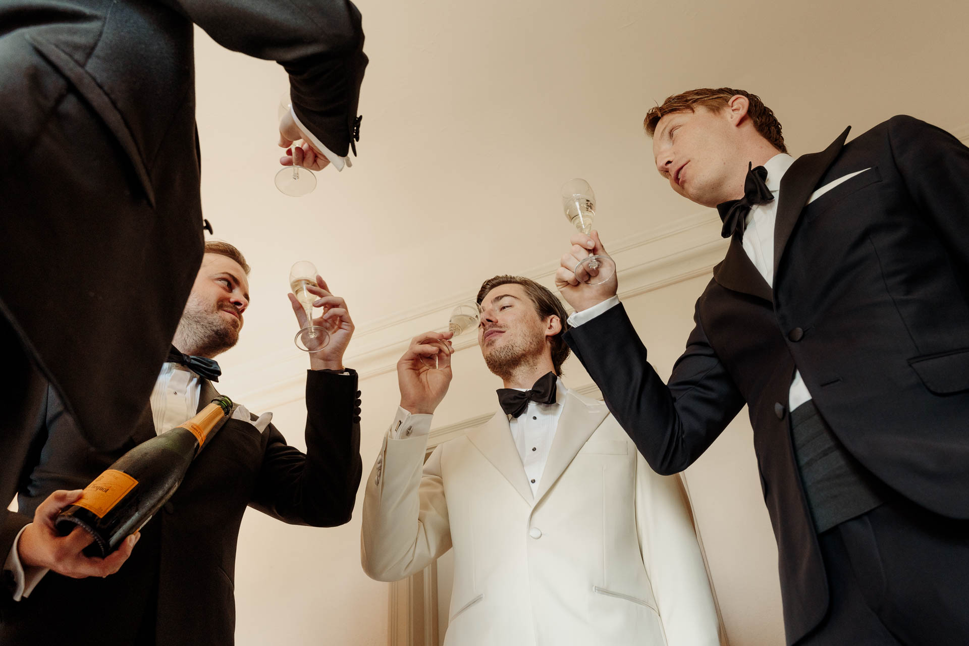 Gli amici versano lo champagne allo sposo, visti dal basso