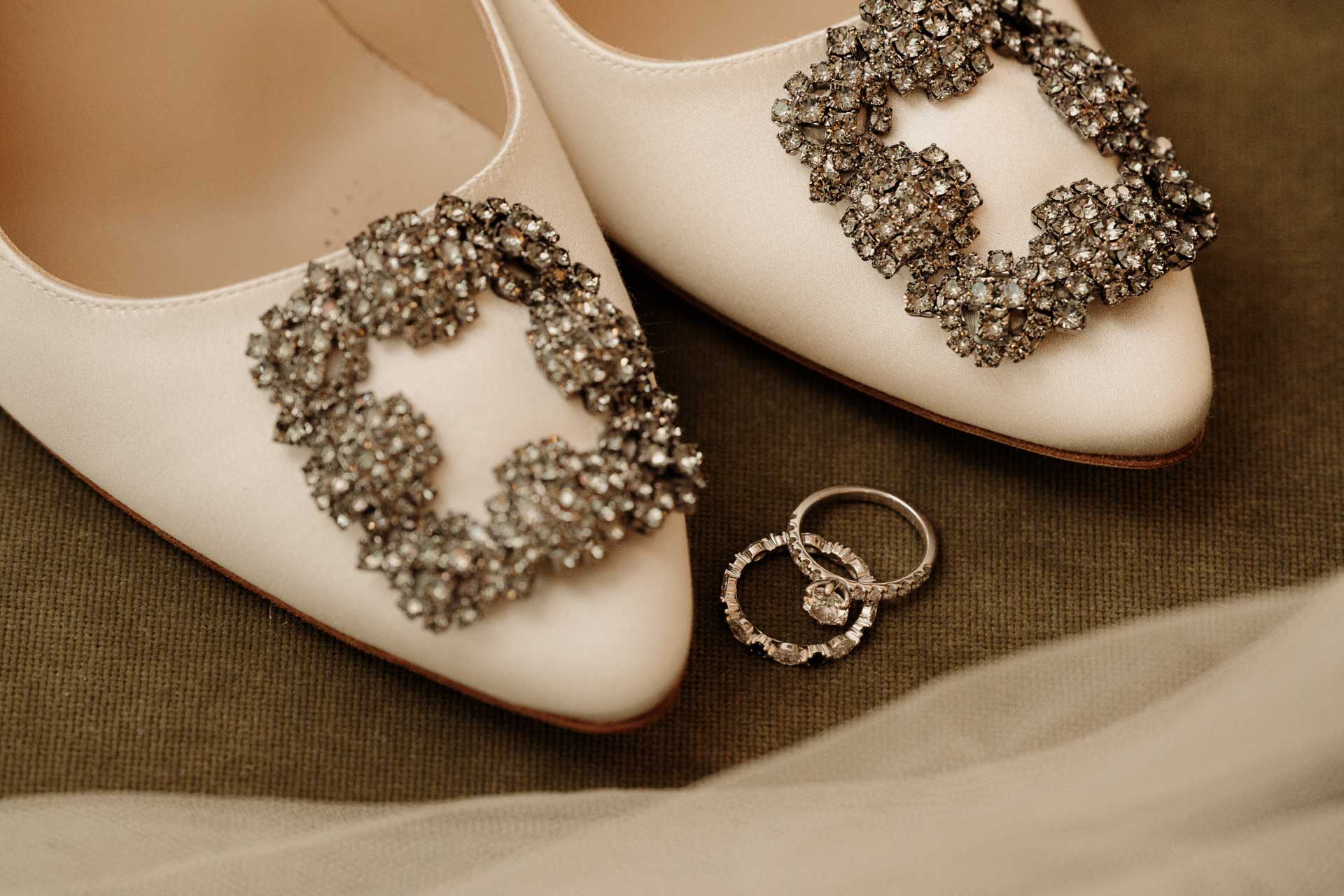 Le scarpe della sposa con la fibbia gioiello e le fedi