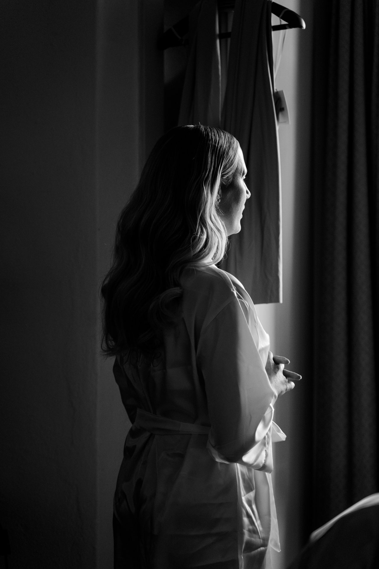 In bianco e nero, la sposa in vestaglia alla finestra