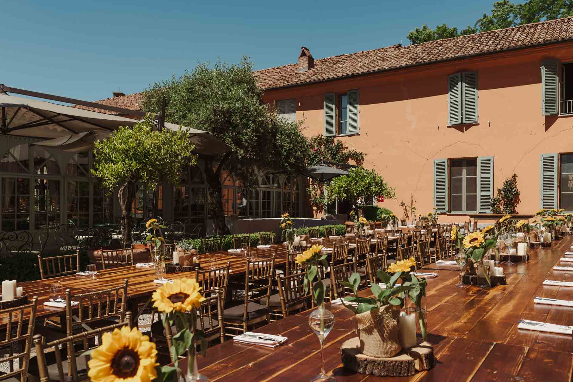 La tavola lunga apparecchiata sulla terrazza, con i girasoli