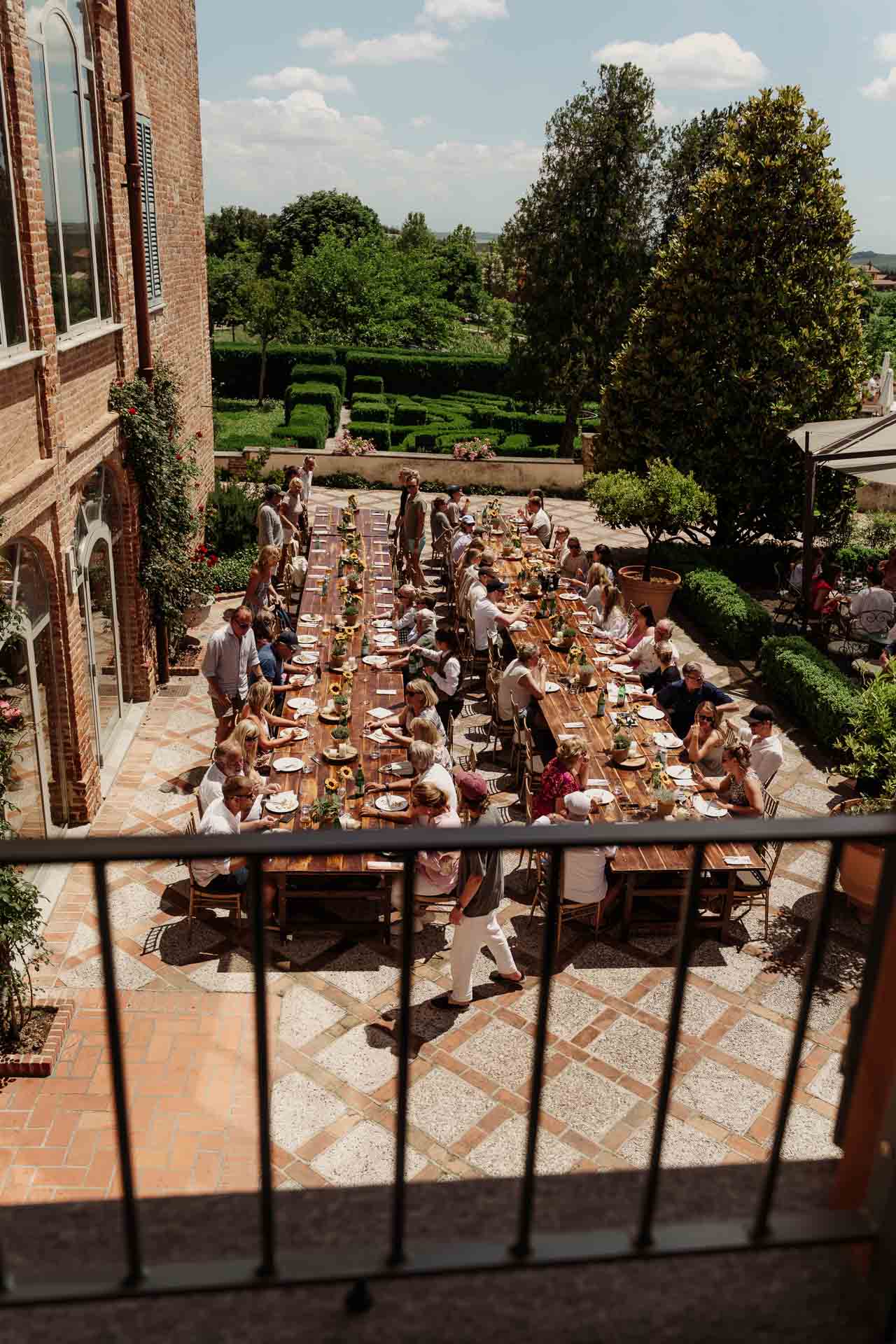 Dall'alto, la tavola lunga sulla terrazza e il giardino all'italiana