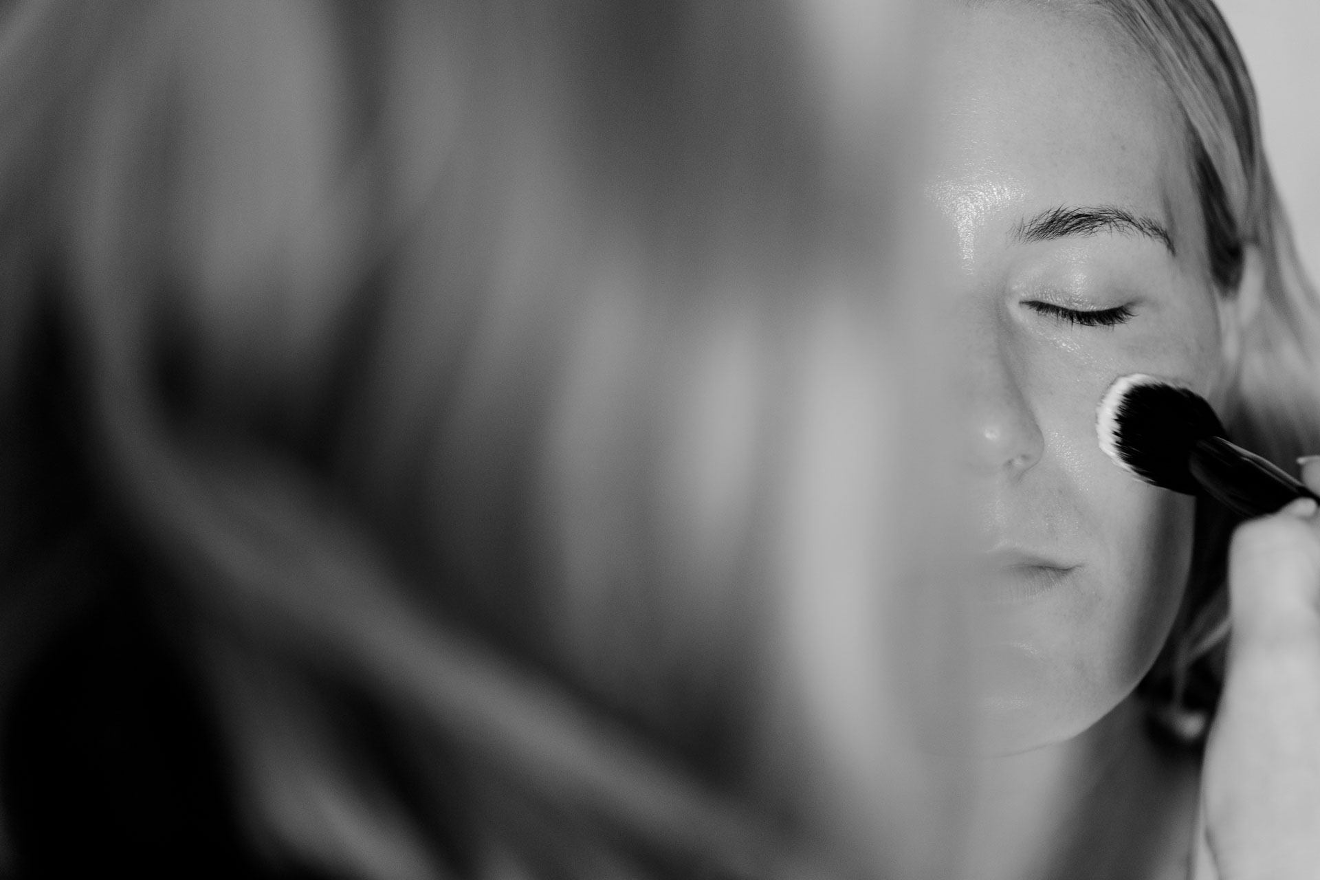In bianco e nero, il pennello del trucco sul viso della sposa