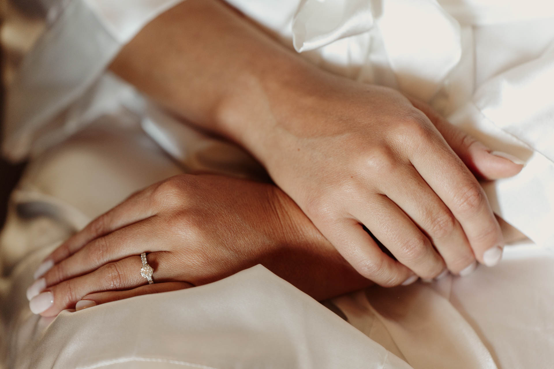 Le mani della sposa con l'anello, sulla vestaglia