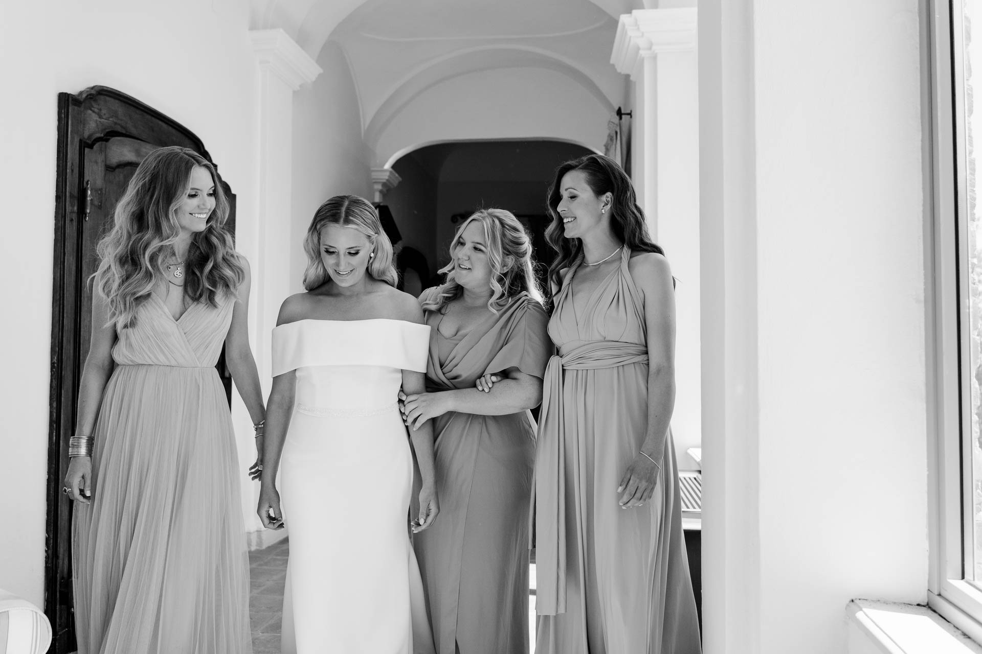 In bianco e nero, la sposa esce dalla camera con le damigelle