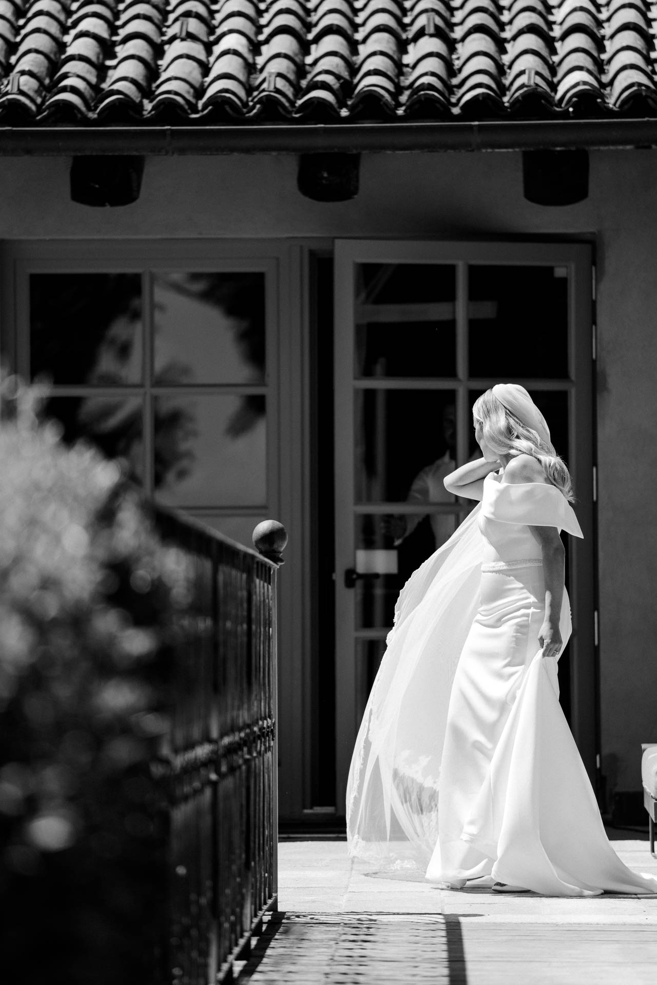 In bianco e nero, la sposa esce dalla porta e scende la scala