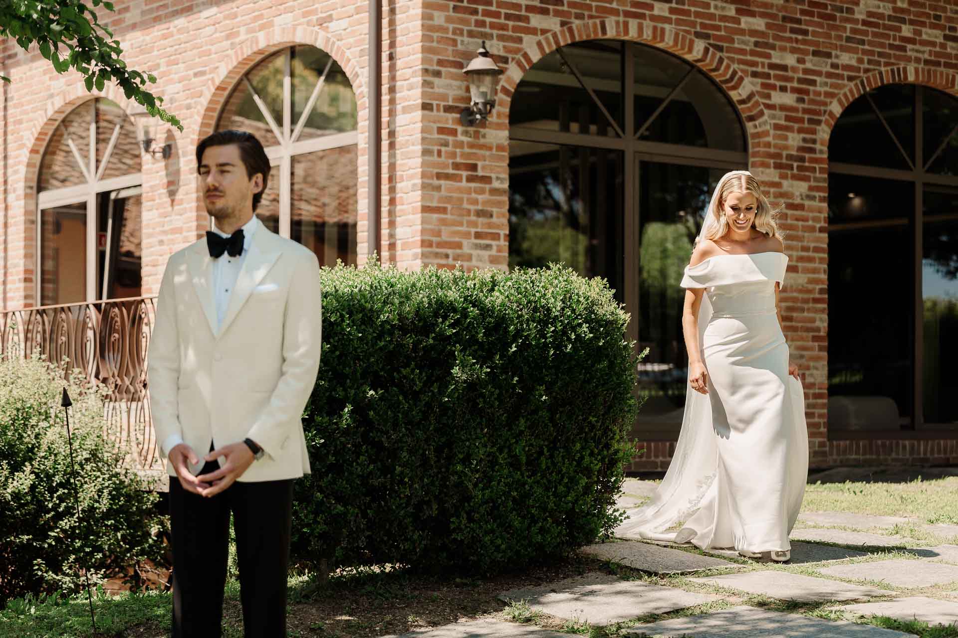 La sposa arriva alle spalle dello sposo davanti alle finestre ad arco