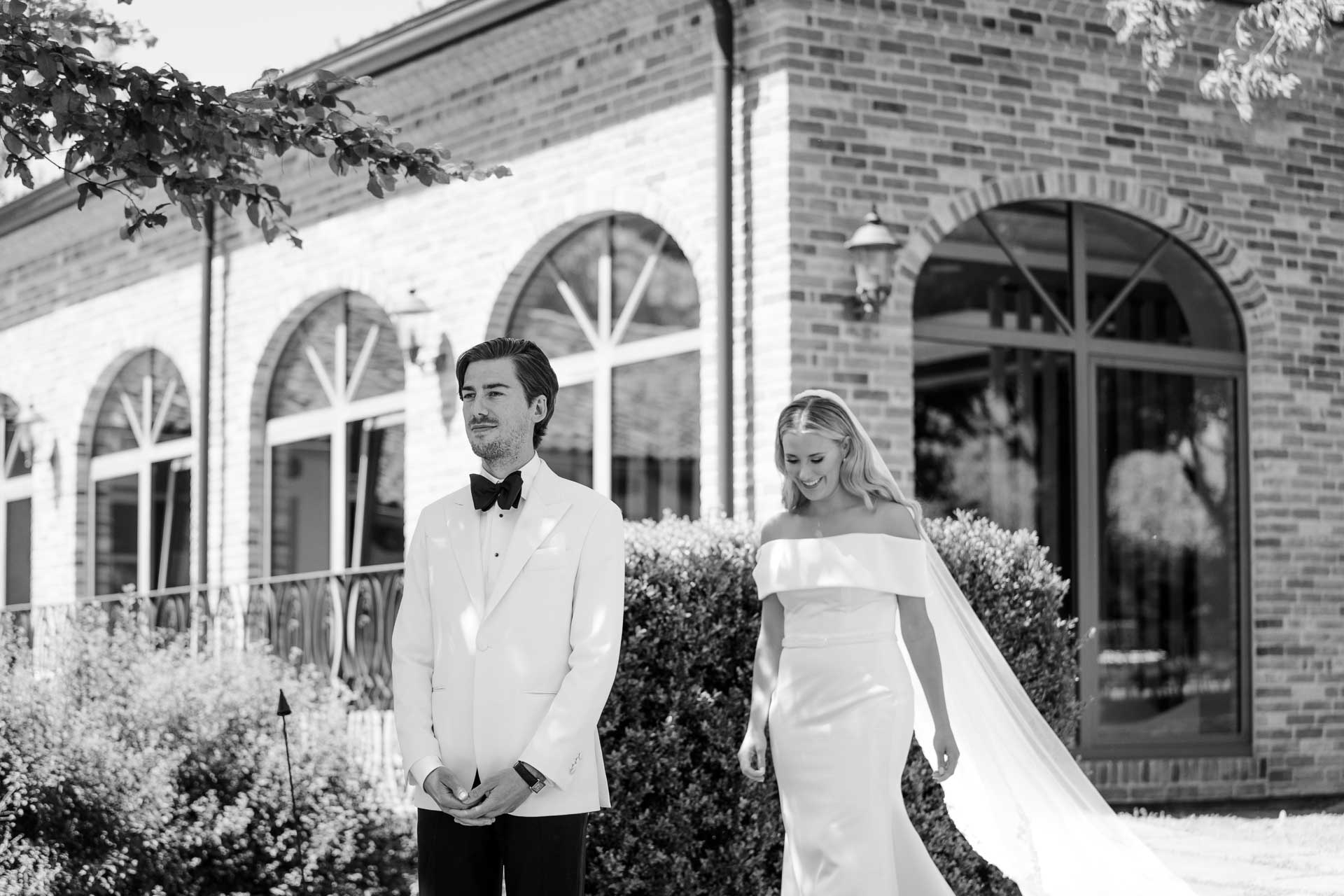 In bianco e nero, la sposa si avvicina allo sposo che aspetta