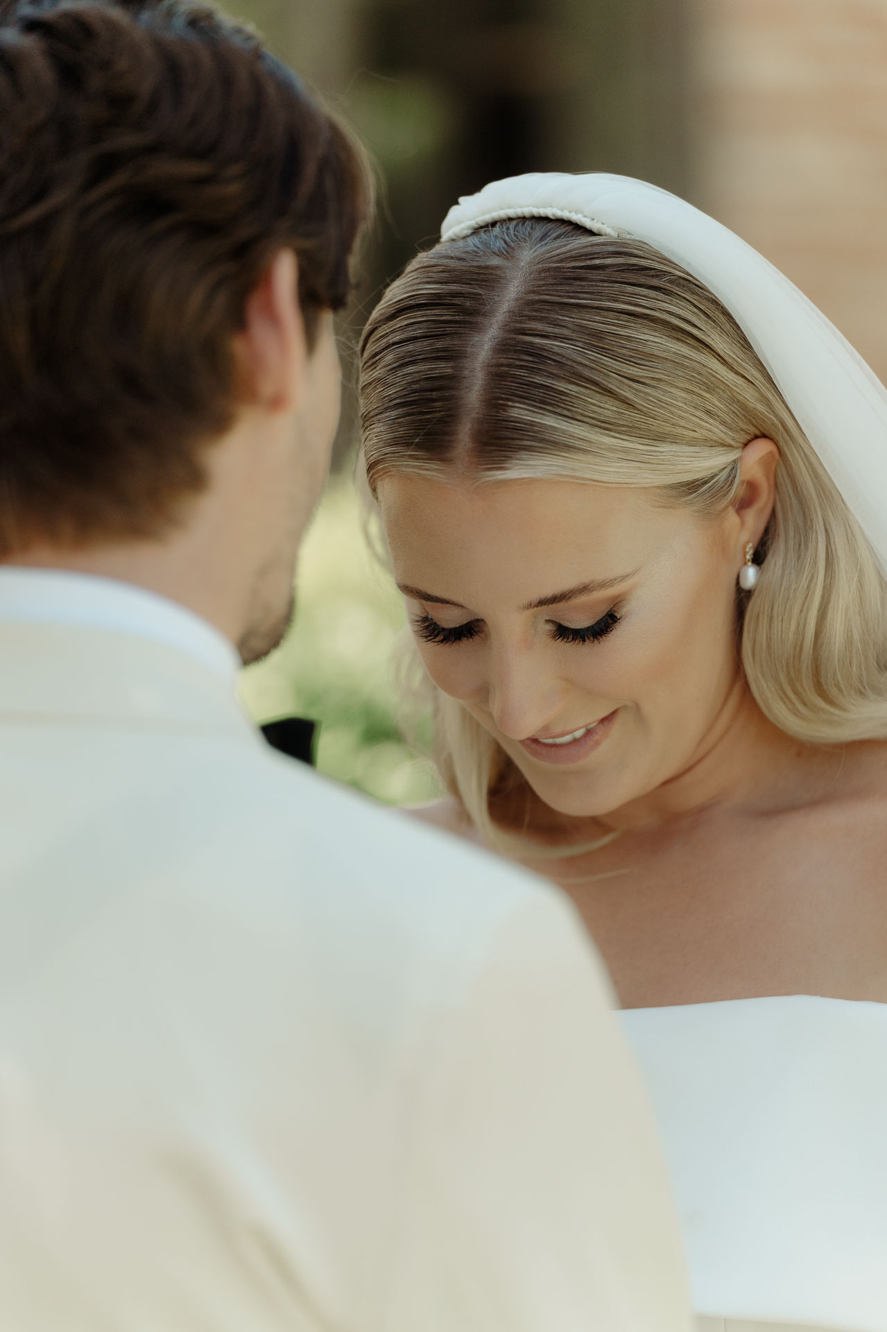 La sposa sorride a occhi bassi davanti allo sposo