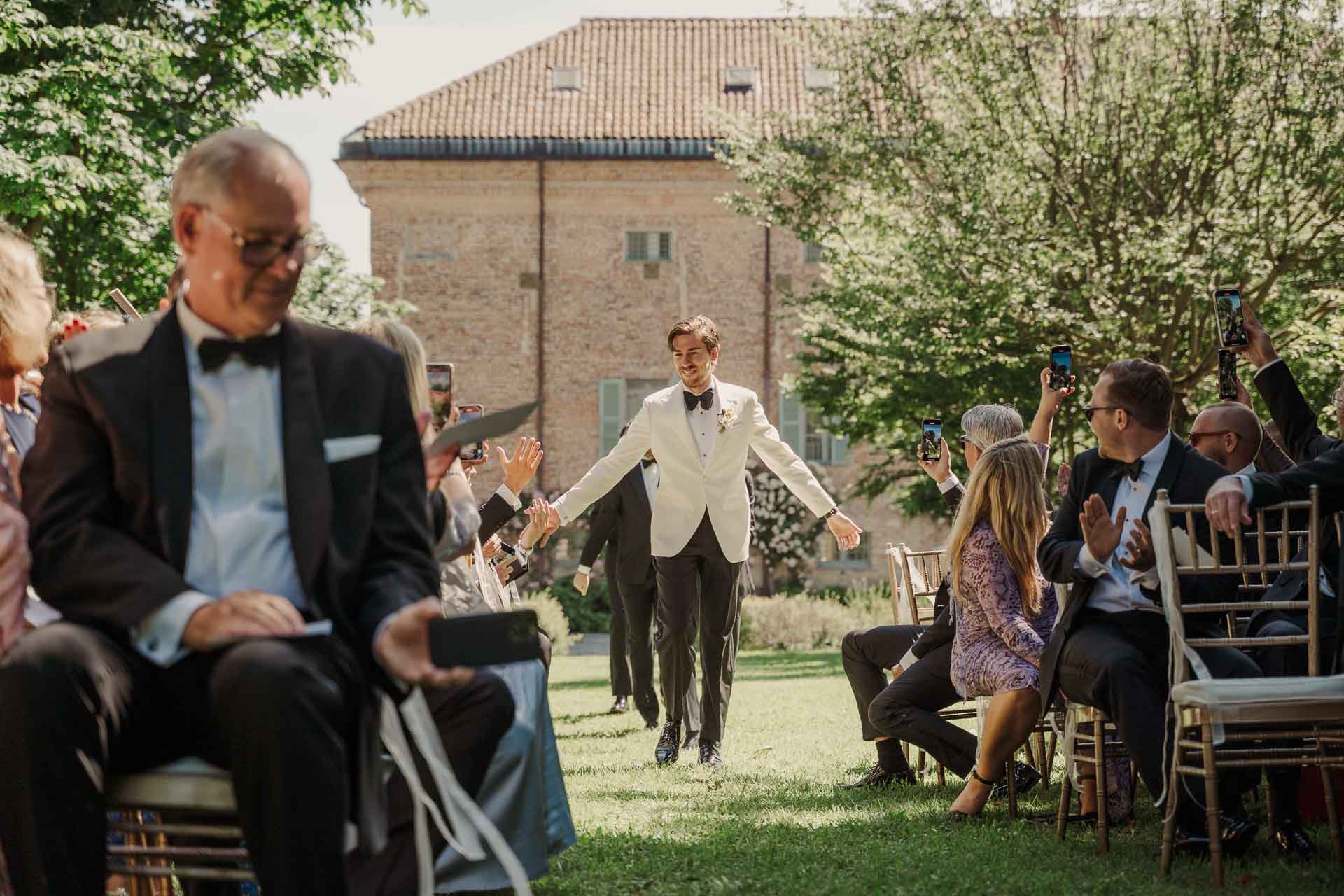 Lo sposo arriva alla cerimonia tra gli invitati