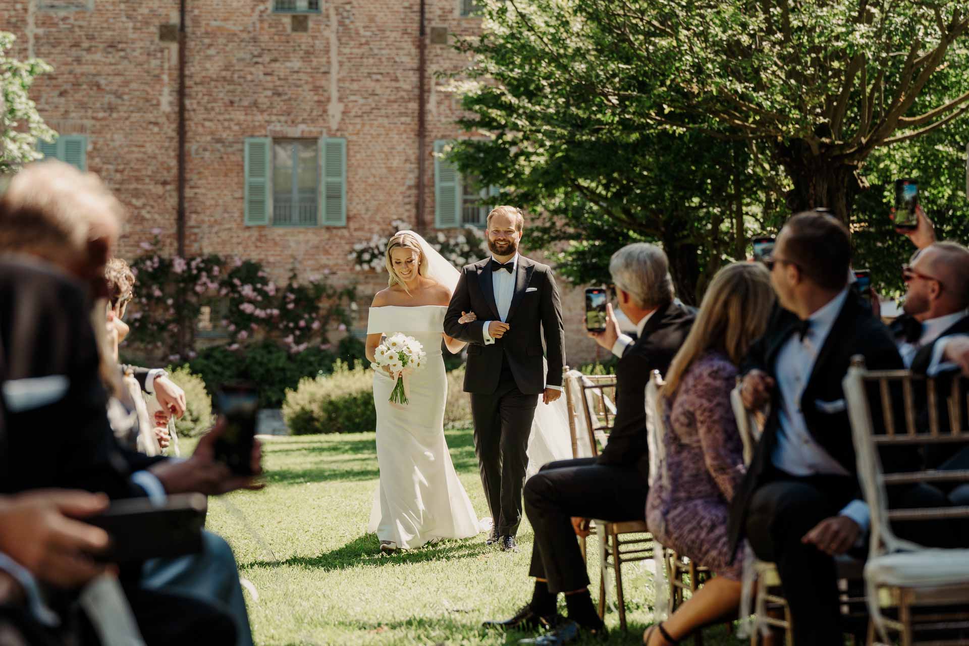 La sposa arriva sottobraccio tra gli invitati